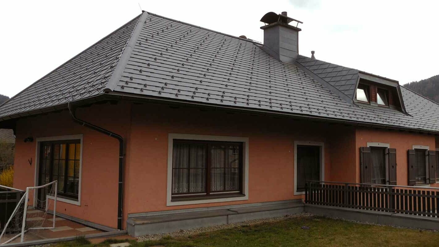 Renovering av tak på et hus med valmtak og trapseformet kvist med bruk av PREFA takshingel