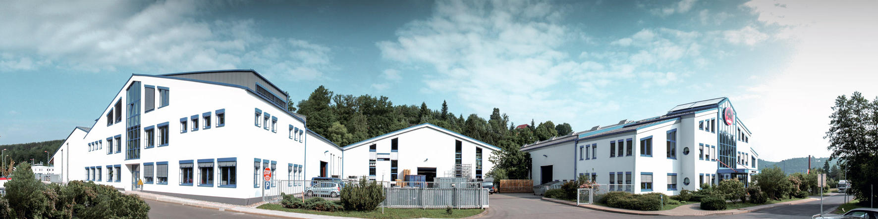 PREFAs firmabygning med blå vinduer og hvit fasade i Wasungen, Tyskland.