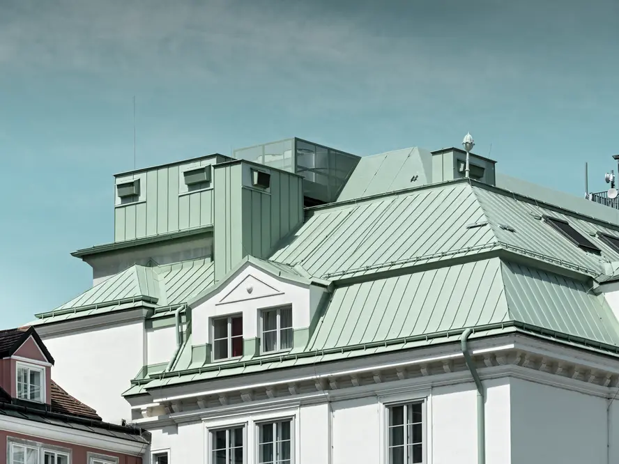 Nahaufnahme der denkmalgeschützten Hauptfeuerwache am Hof in Wien bei blauem Himmel, eingedeckt mit PREFALZ in der Sonderfarbe Opalgrün.