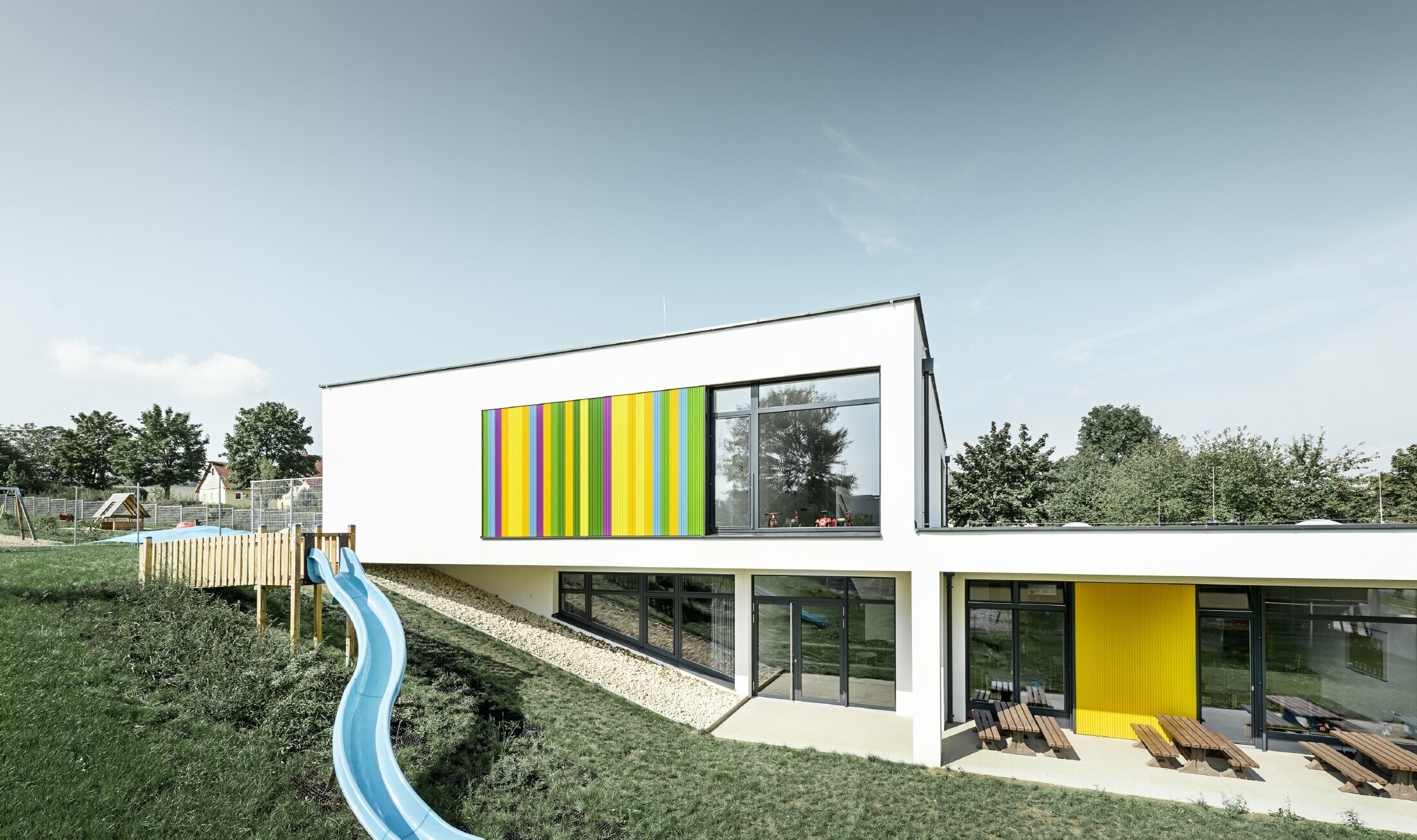 Baksiden av  barnehagen i Hargelsberg med PREFA sikksakkprofil i fargene gul, grønn, lilla og blå
