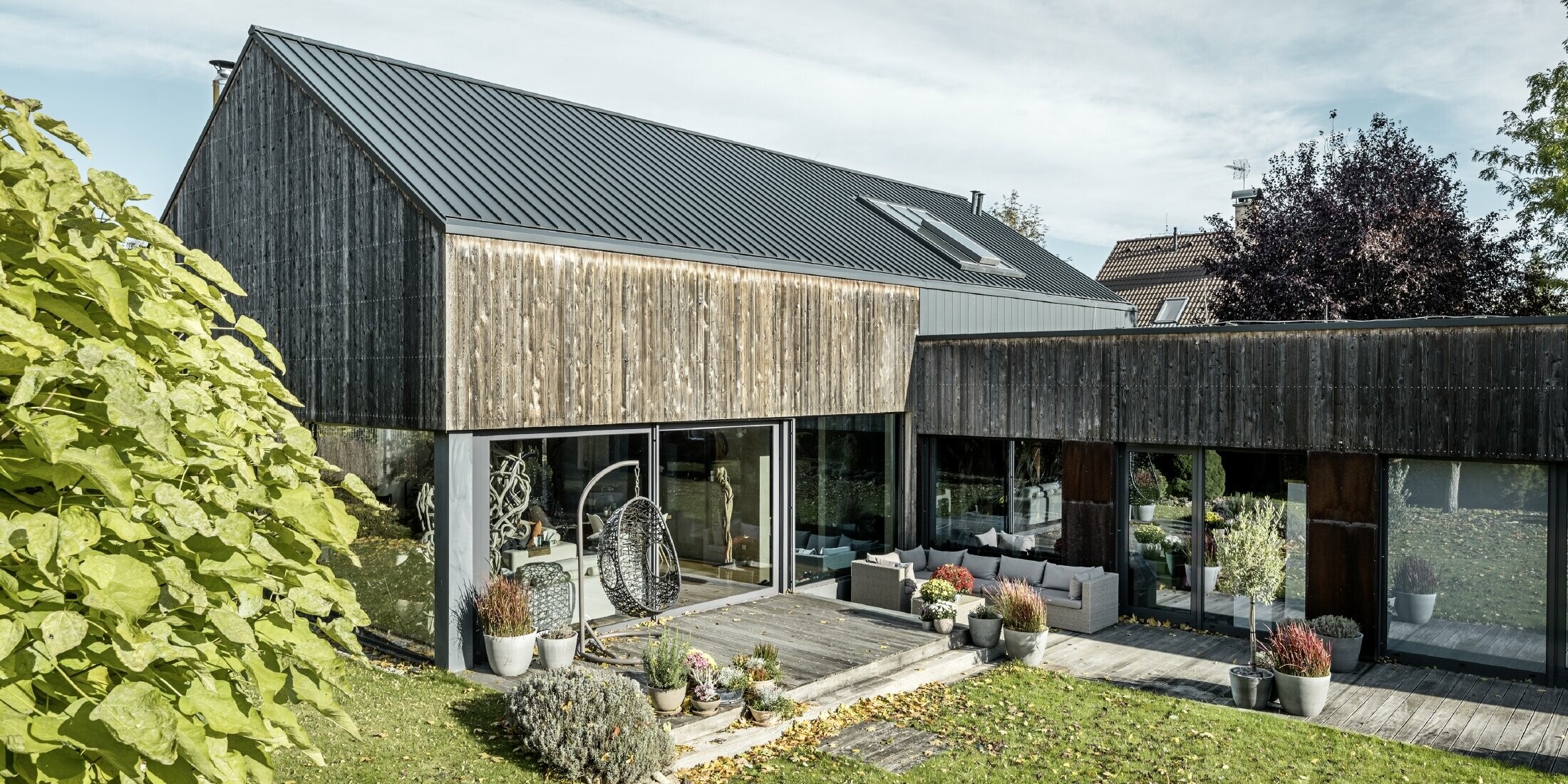 Enebolig med saltak, tekket med stående dobbeltfals PREFALZ i antrasitt og barsk trefasade. Med flott treterrasse og store vindusflater i første etasje.