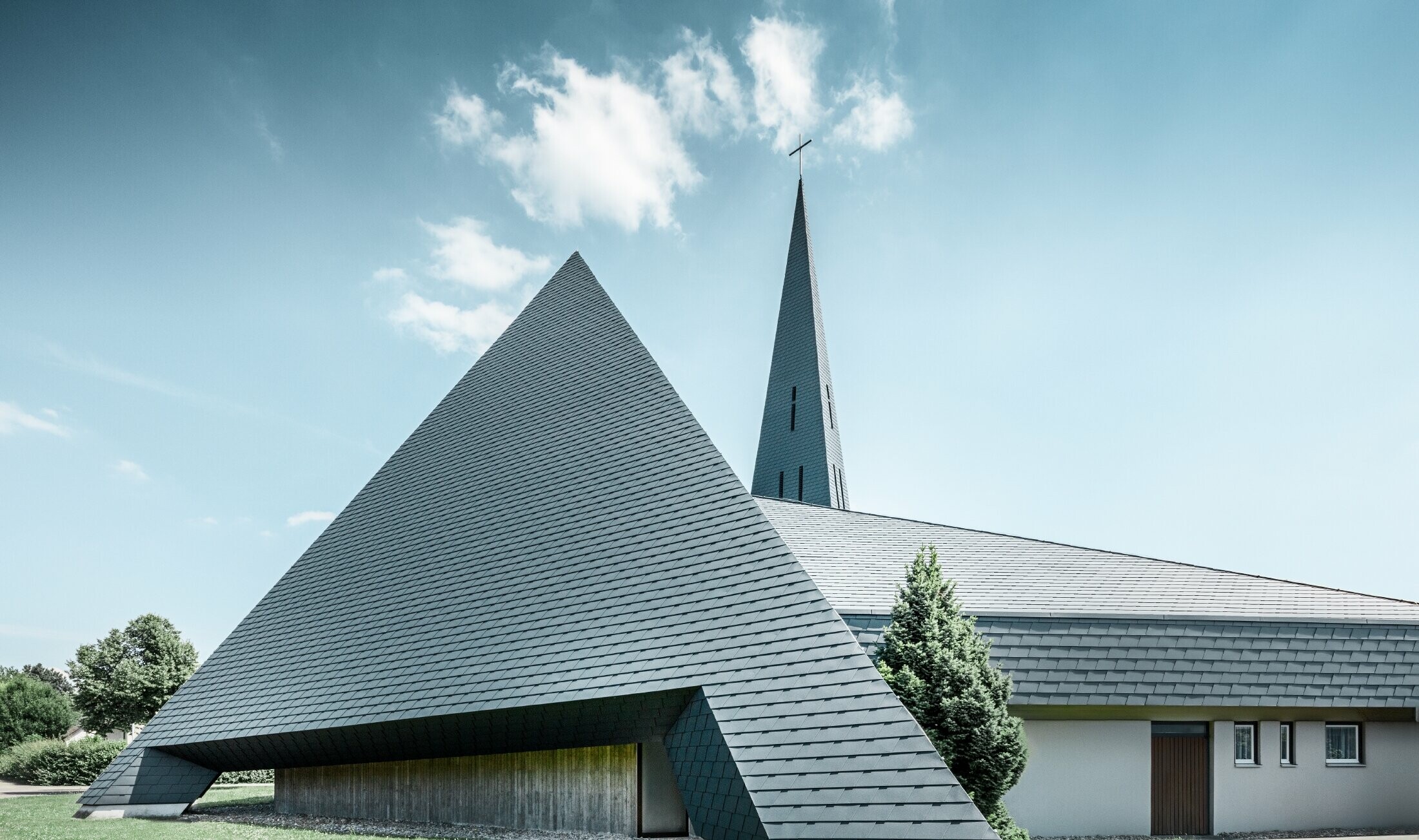 katholische Kirche in Langenau mit einem Design ähnlich einer Pyramide eingedeckt mit PREFA Aluminiumschindeln in anthrazit