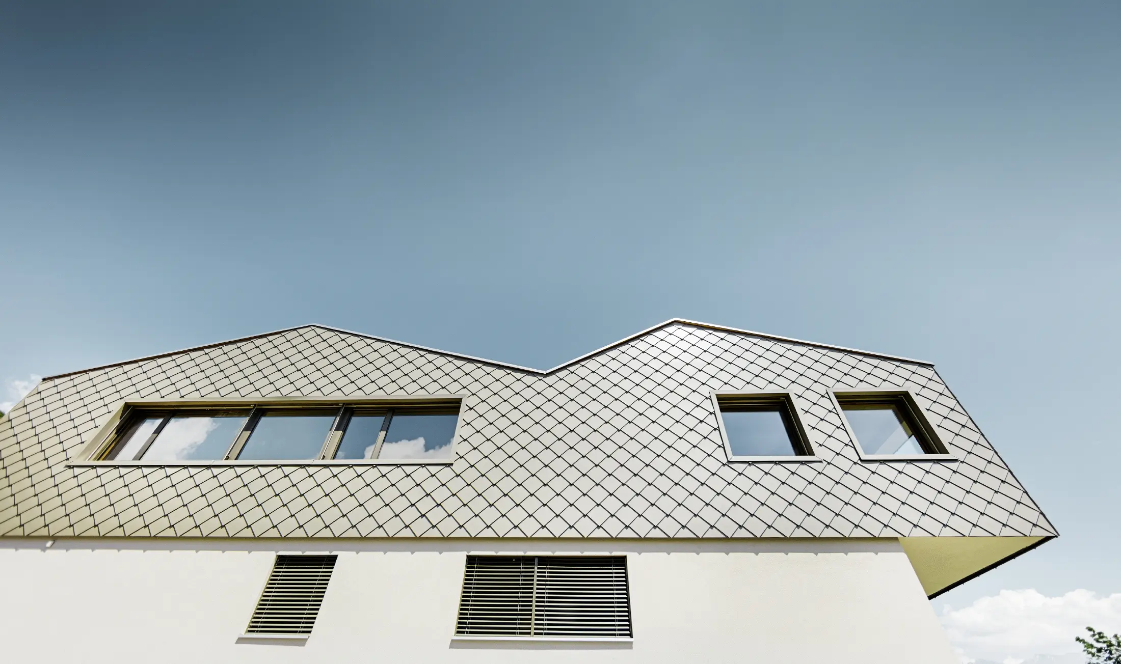 Moderne frittliggende hus midt i vinmarkene i Rhône-dalen med 4 forskjellige takflater og åpent galleri med en rombefasade i bronse