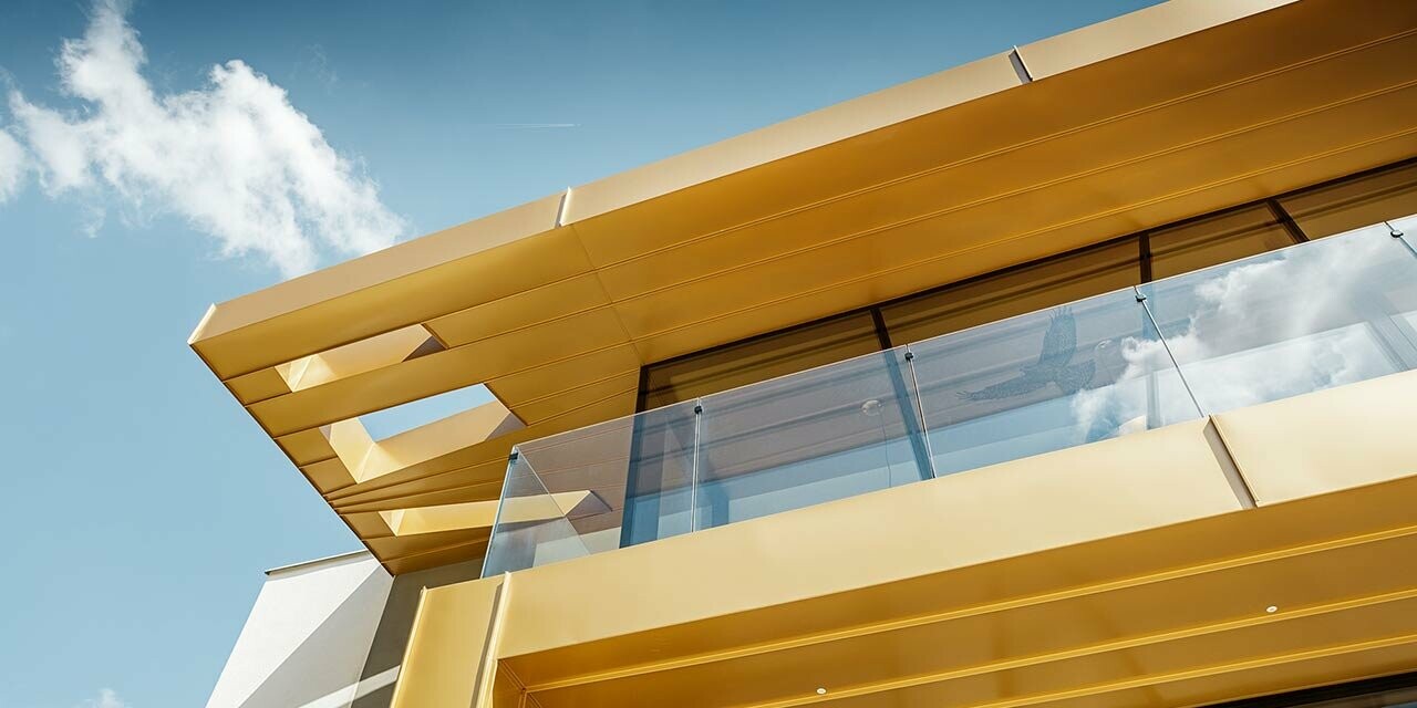 Neu gebautes Weingut Rúbaň mit großen Glasflächen und einer Aluminiumfassade in mayagold