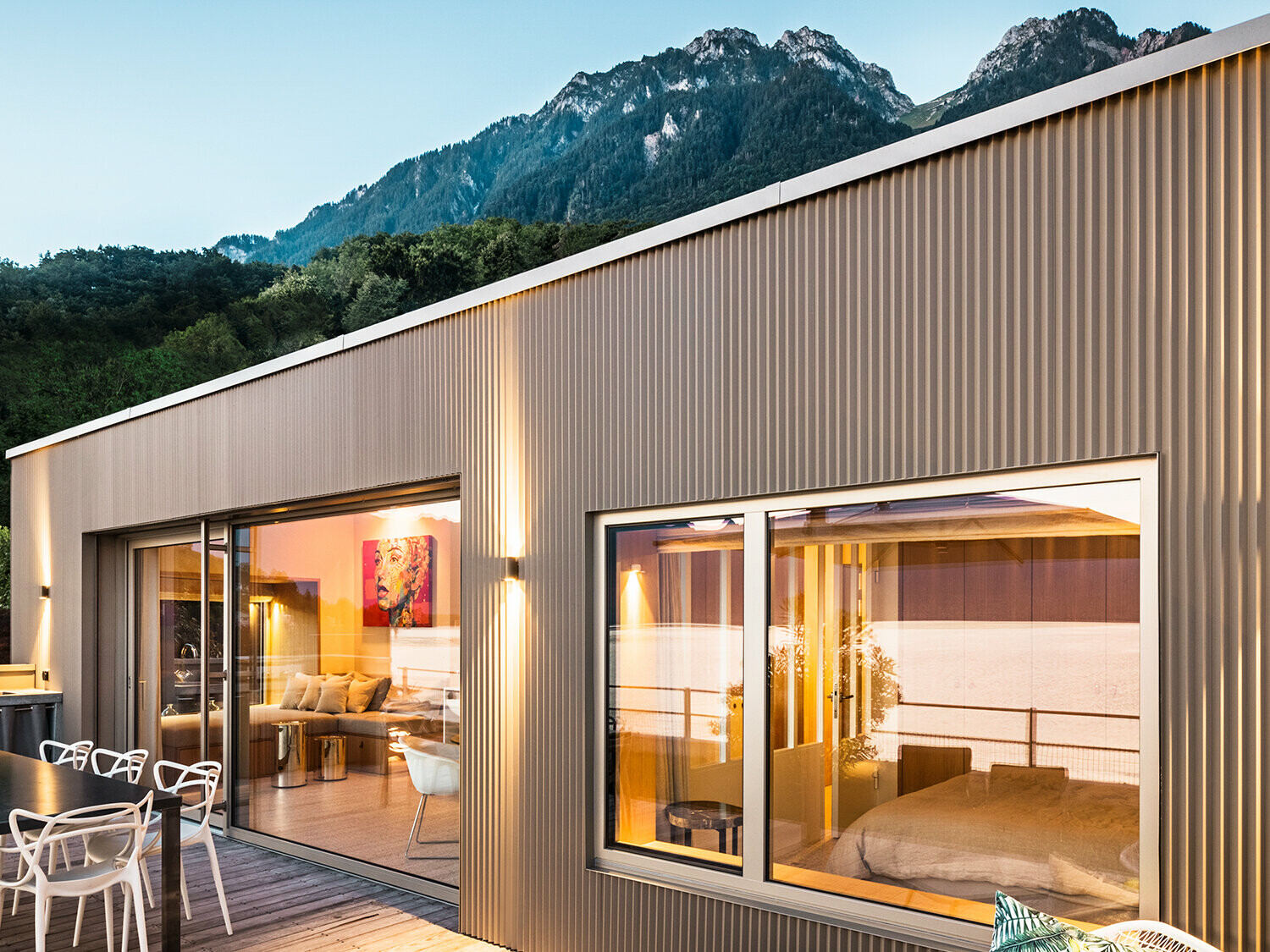 Terrassen og del av rommet innenfor i kveldslys.