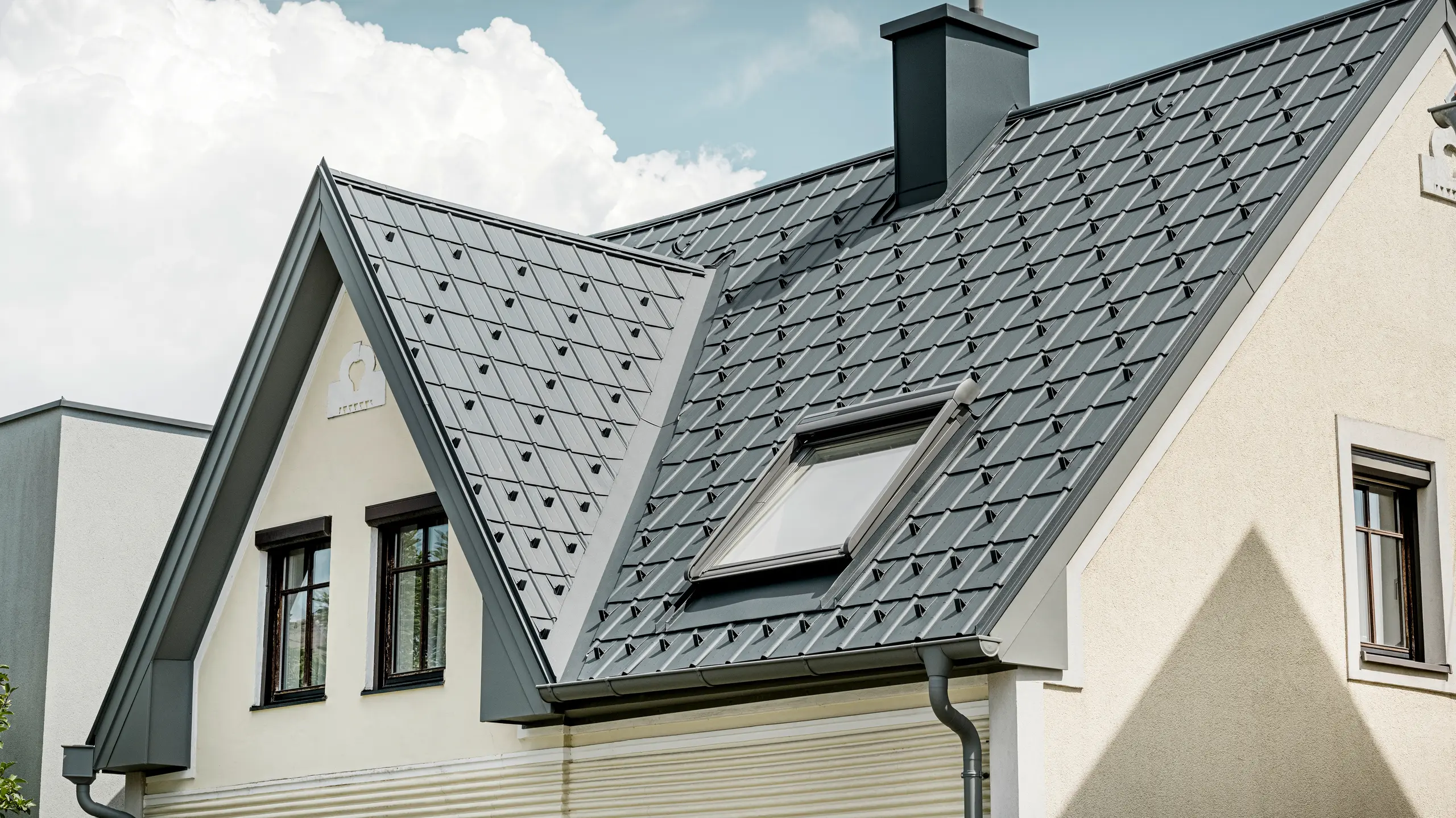 Einfamilienhaus in St. Valentin mit PREFA Dachplatte in anthrazit und einem Dachentwässerungssystem von PREFA in hellgrau