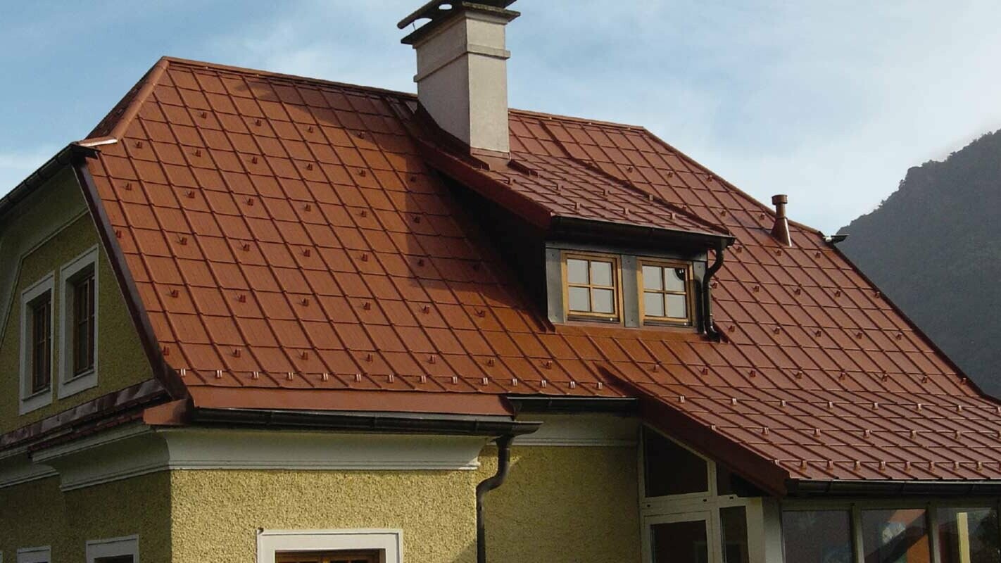 Enebolig med halvvalmtak og kvist med nyrenovert tak med PREFA takplate i mursteinsrødt