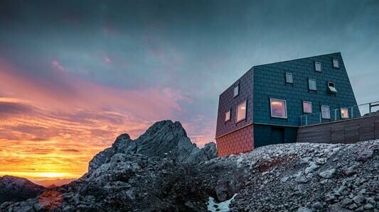 Ekstraordinær arkitektur i fjellet: Seethalerhütte på Dachstein dekket med PREFA tak- og fasadepanel Fx.12 i steingrått.