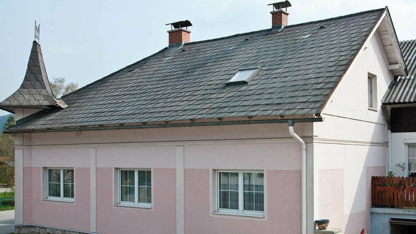 Hus før renovering av taket med PREFA takplate i Østerrike – før Eternit-fibersement og tårn, rosa fasade