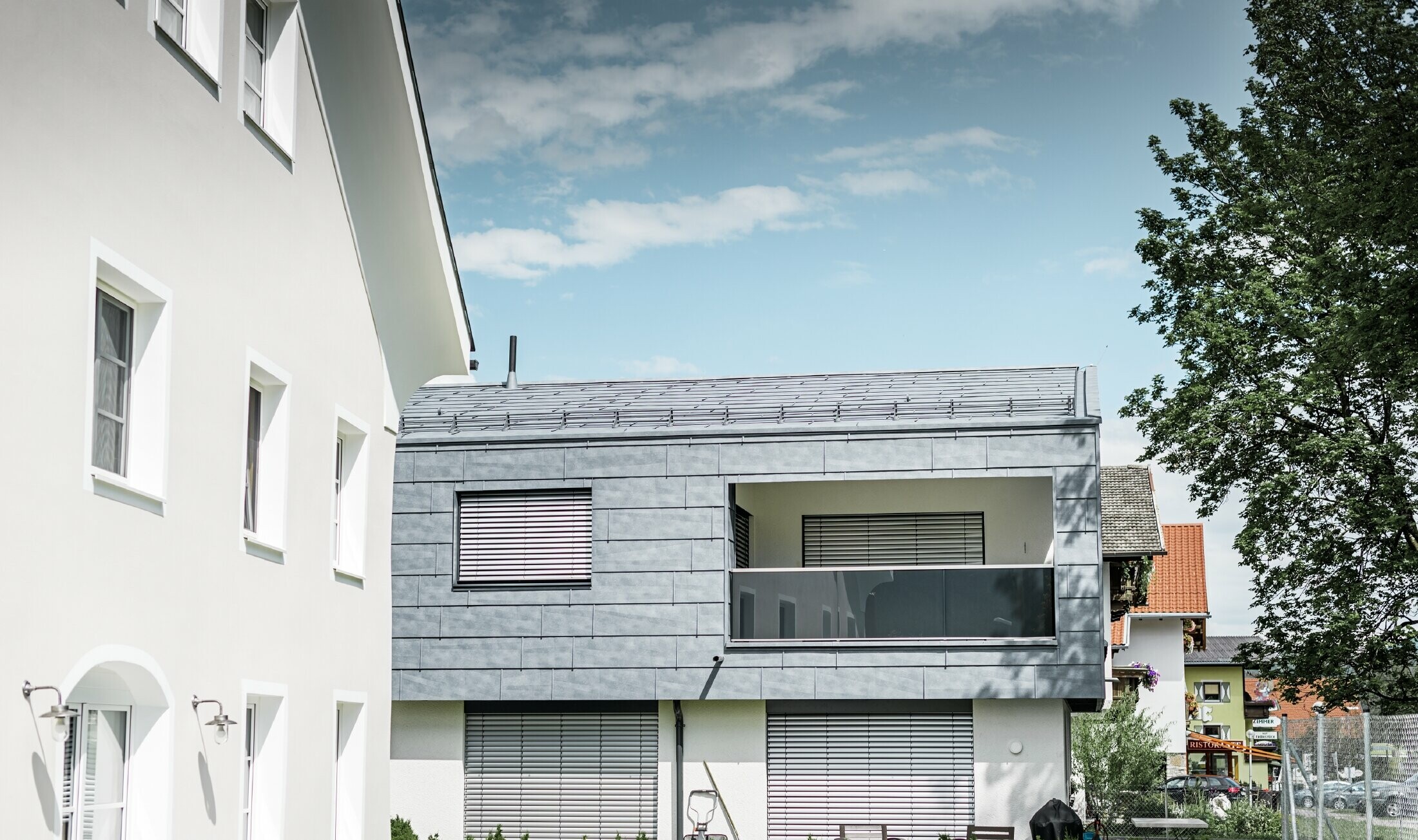 På bolighuset i Mieming er hele den øverste delen av bygningen kledd med PREFA fasadepanel FX.12 i steingrå.