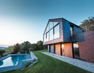 Aluminiumfasaden  til en villa med PREFA fassadepaneler FX.12 i P.10 antrasitt ved solnedgang. 
