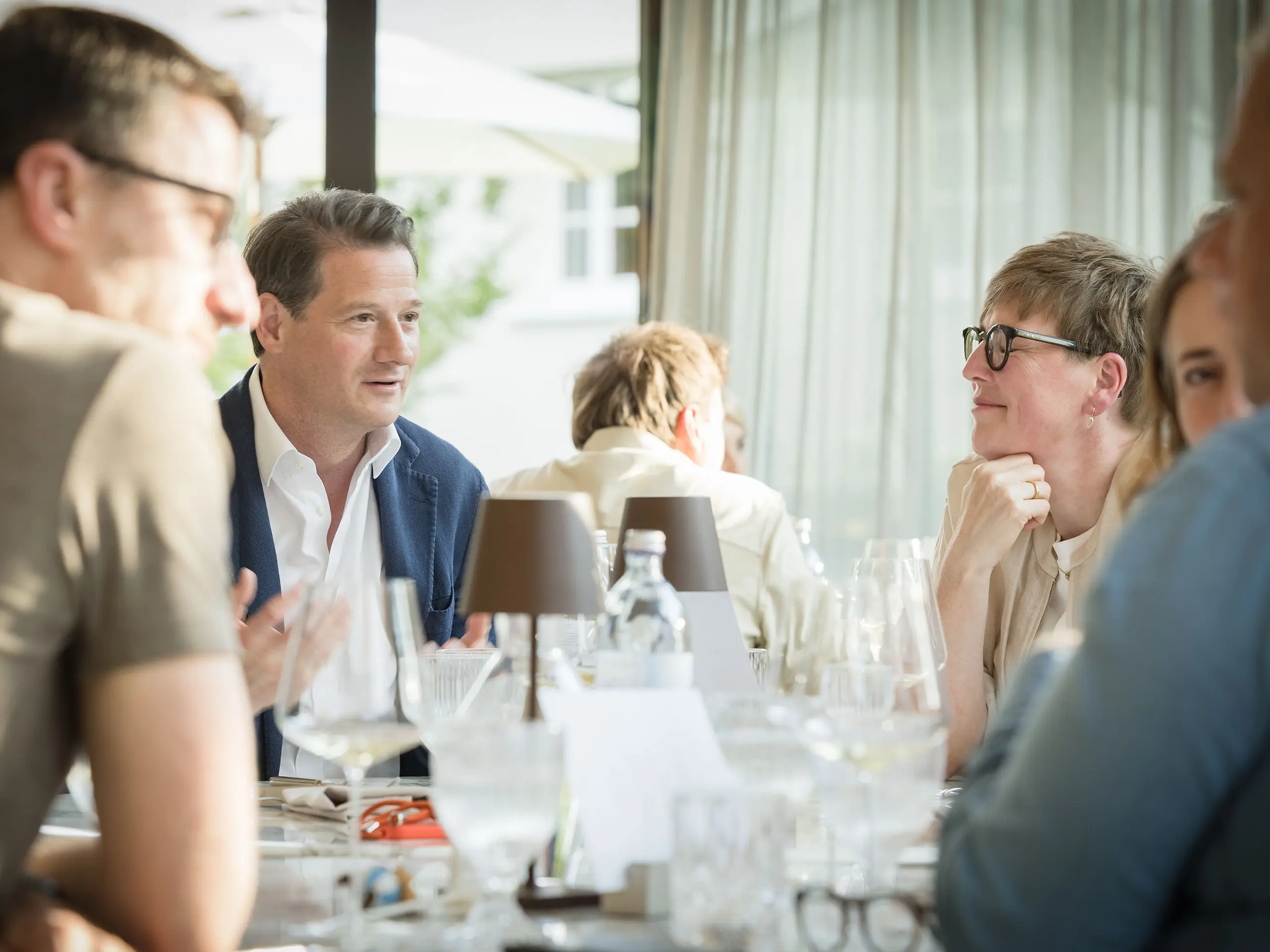 Die Expertenjury bei den PREFARENZEN 2027 in der malerischen Winzerresidenz im burgenländischen Seewinkel im intensiven Dialog. Im Vordergrund zu sehen ist Leopold Pasquali, PREFA Geschäftsführer, während die natürliche Lichtführung durch große Fenster die Szene dynamisch beleuchtet.
