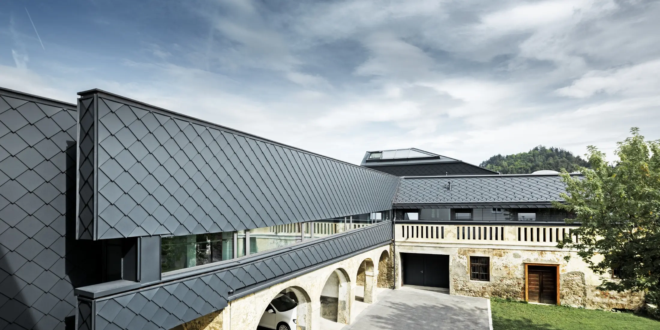 Denkmalgeschütztes Gebäude wurde im Obergeschoss mit der PREFA Wandraute 29 in Anthrazit verkleidet, so harmonieren die alten Strukturen im Erdgeschoss perfekt mit den neuen Rauten.