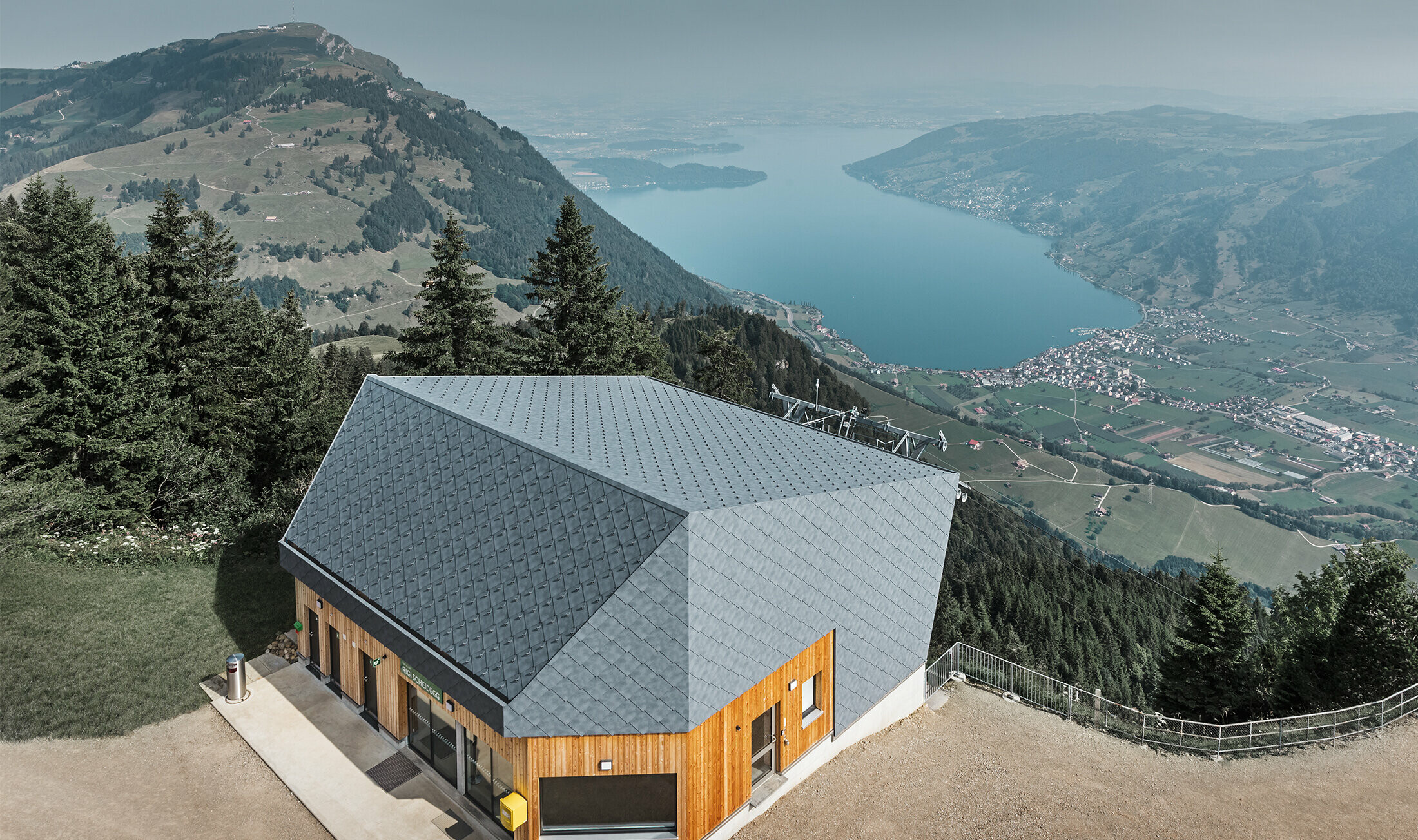 Luftfoto av Scheidegg fjellstasjon på Rigi kabelbane, kledd med PREFA veggrombe 44 × 44 i P.10 steingrå og tre.