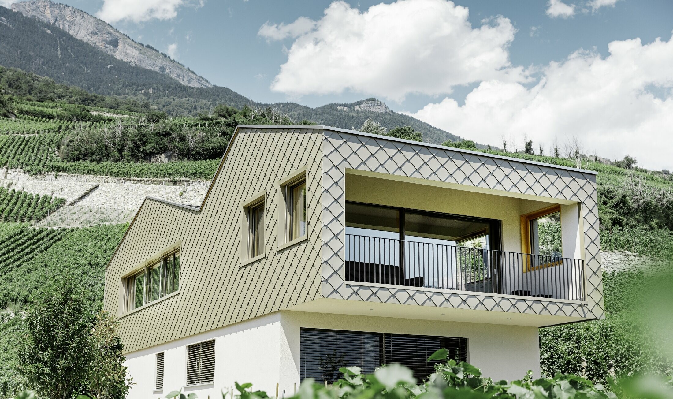 modernes Einfamilienhaus mitten in den Weinbergen des Rhônetals mit 4 unterschiedlichen Dachflächen und offener Galerie mit einer Rautenfassade in bronze