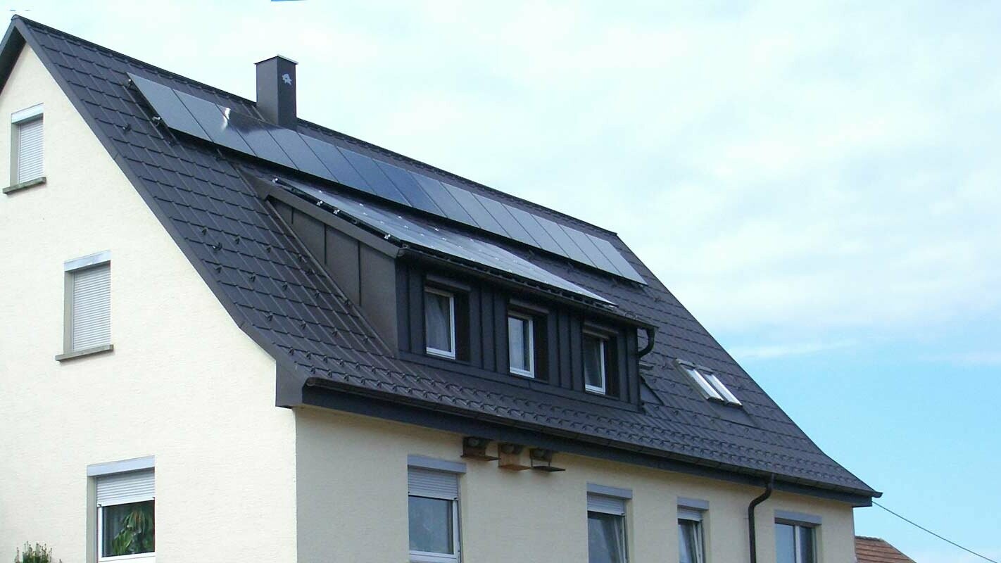 Nyrenovert tak med PREFA takplate i antrasitt, kvisten er kledd med Prefalz, på taket er det et solcelleanlegg.