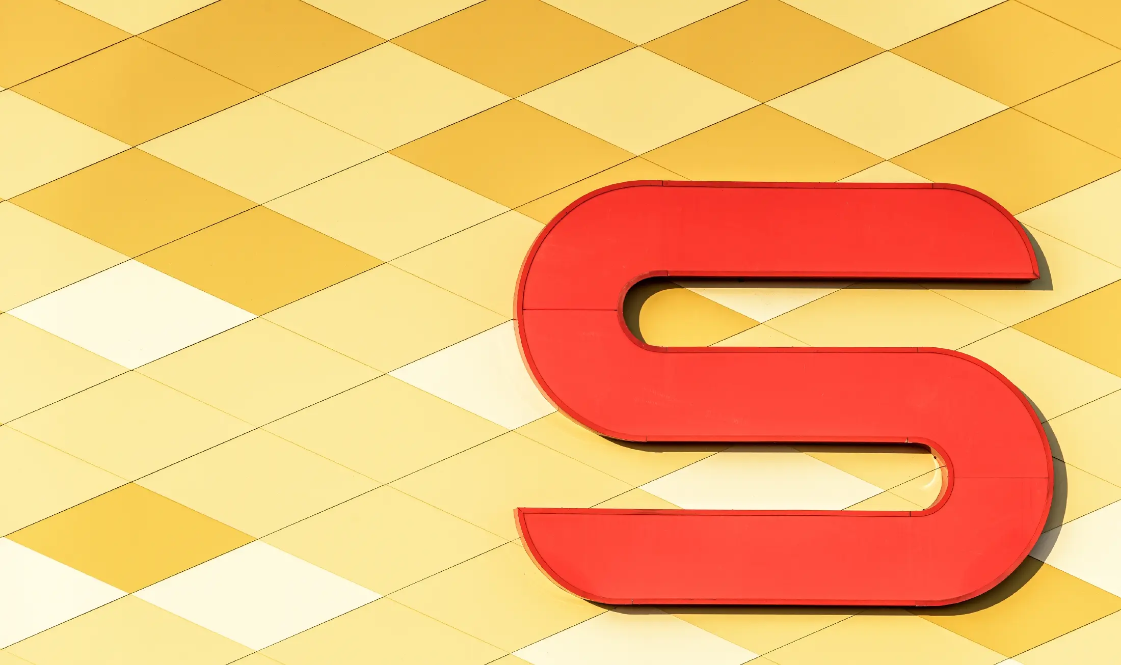 Spar Filiale mit einer Aluminiumfassade in gelb-orangen Karos und Spar Logo