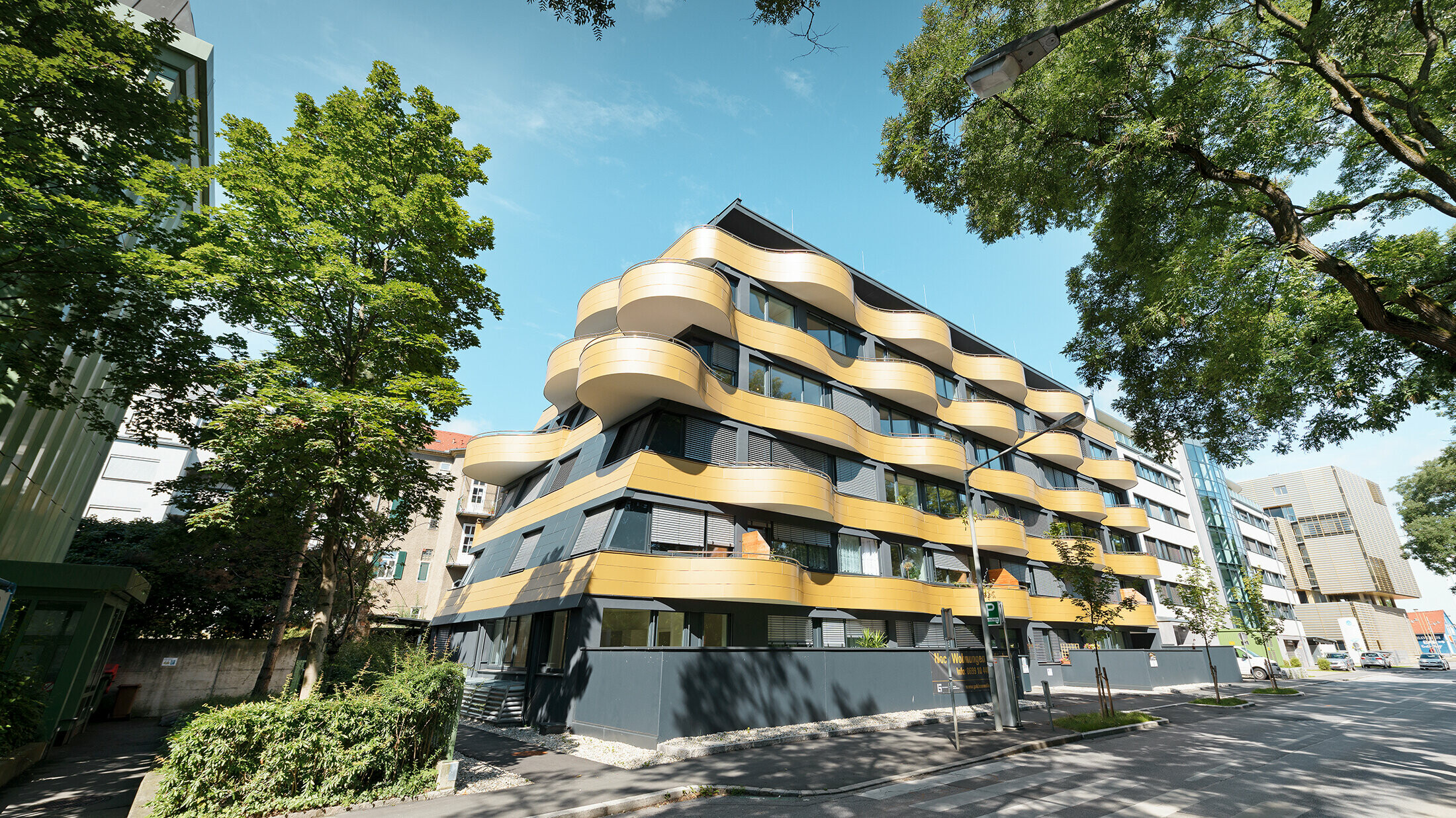 Boligområdet "Goldene Welle" i Graz, Østerrike, med aluminiumskomposittplate i gull, balkongene er avrundet i bølger 