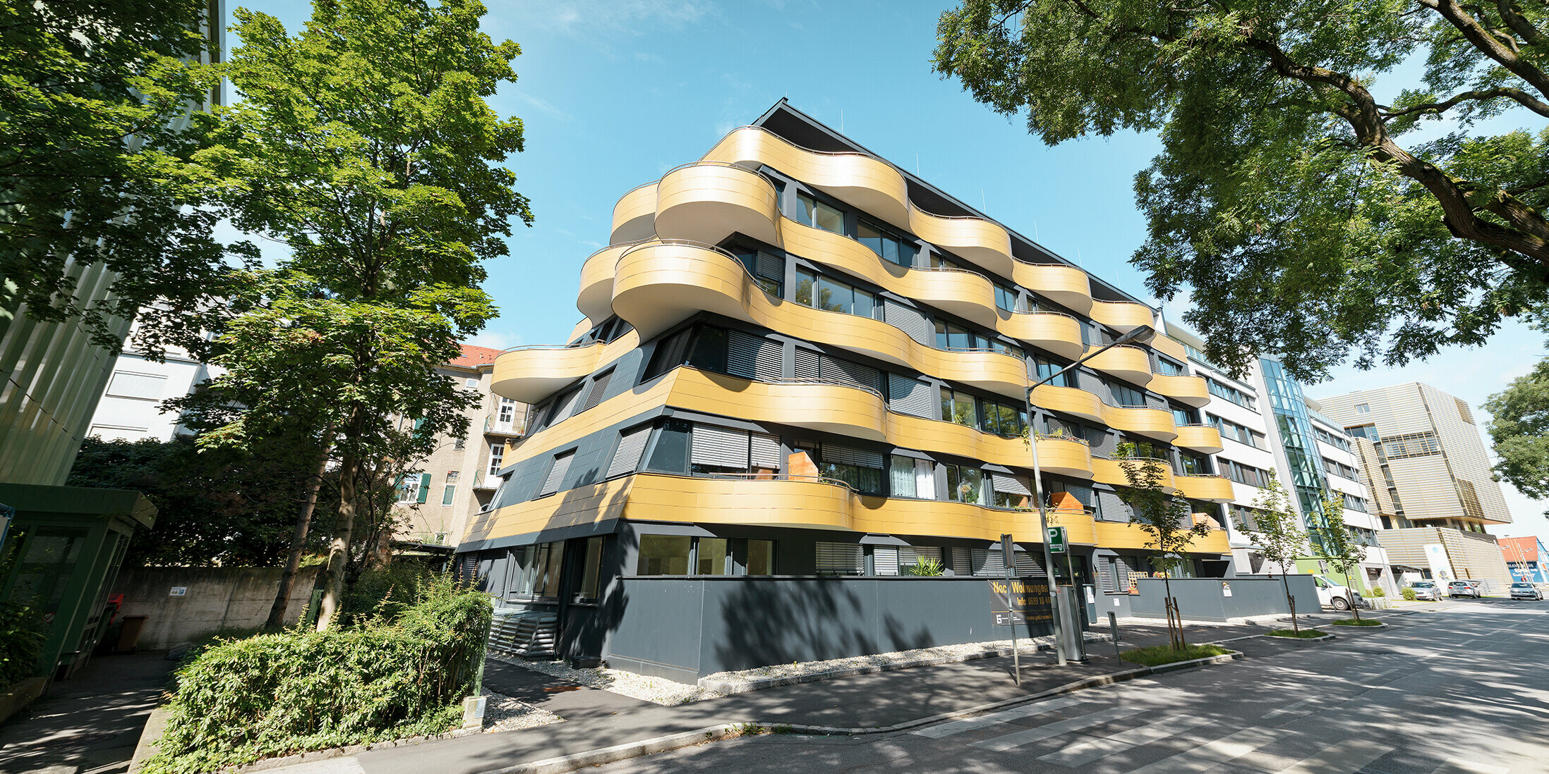Boligområdet "Goldene Welle" i Graz, Østerrike, med aluminiumskomposittplate i gull, balkongene er avrundet i bølger 