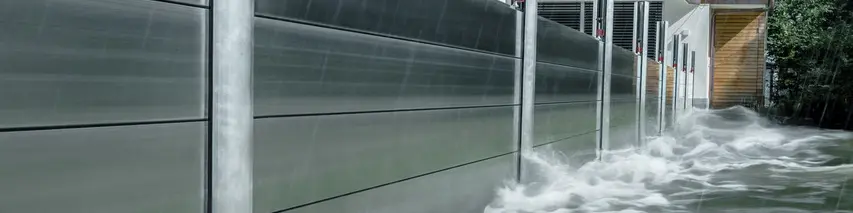 Nærbilde av PREFAs flomvern i aluminium, som alltid tåler flomkatastrofer og beskytter eneboligen i bakgrunnen.