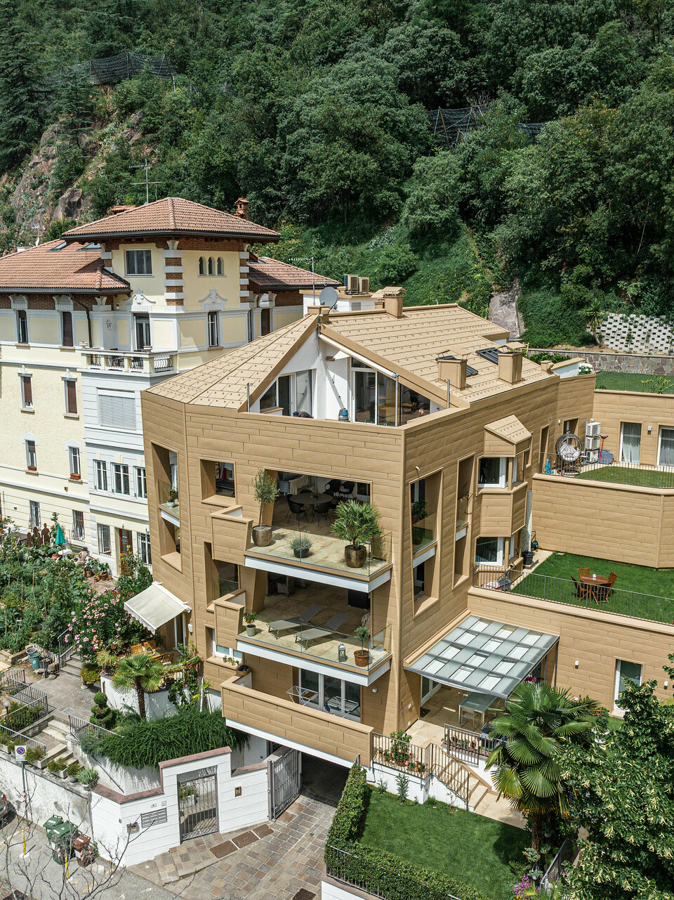 Architektonisches Meisterwerk: Die Villa Laura in Südtirol ist umhüllt von PREFA Aluminium in P.10 Sandbraun. Die innovativen Kantungen der Dachpaneele FX.12 und Siding.X prägen das einzigartige Design der Wohnanlage und verleihen ihr eine dynamische und moderne Ausstrahlung, die nahtlos mit der umgebenden Natur verschmilzt. Das hochwertige und langlebige Aluminium gewährleistet eine elegante Ästhetik sowie eine dauerhafte Beständigkeit gegen Witterungseinflüsse.