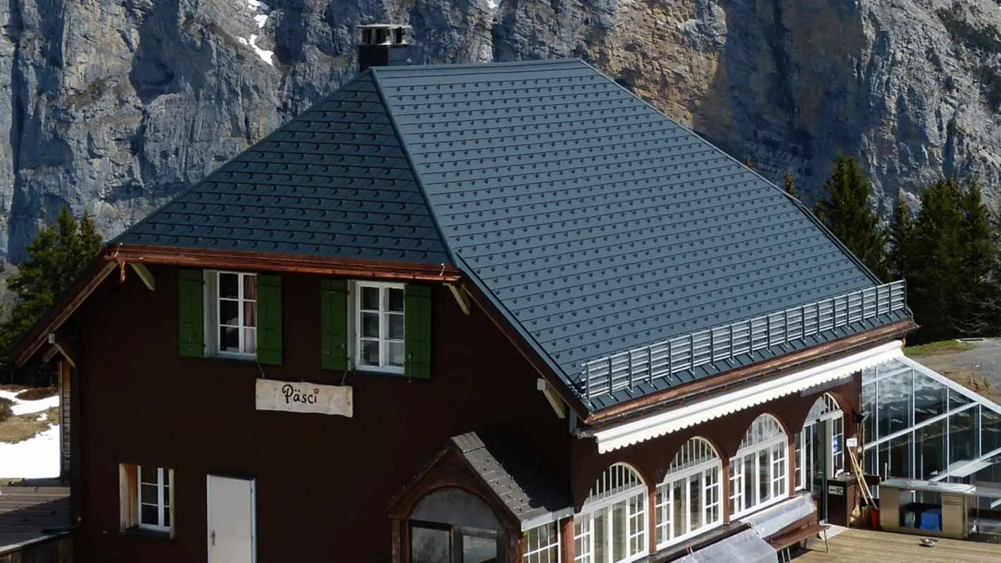 Renovering av tak på en fjellhytte med halvvalmtak med PREFA takshingel og snøfangere