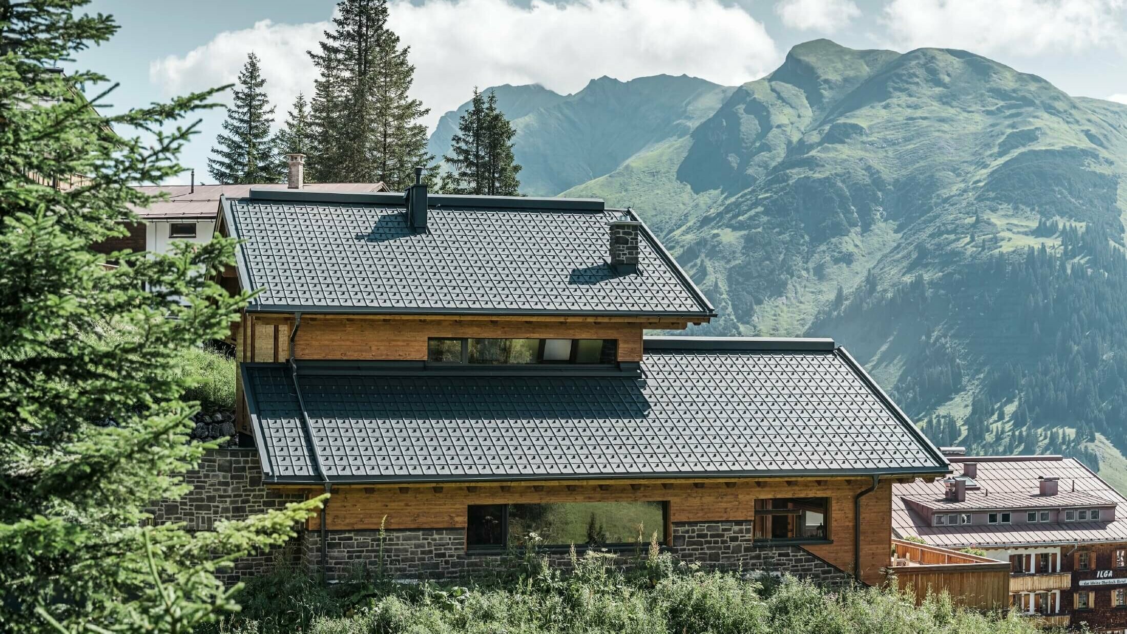 Hus i fjellandskap der taket er dekket med antrasittfargede PREFA-takplater