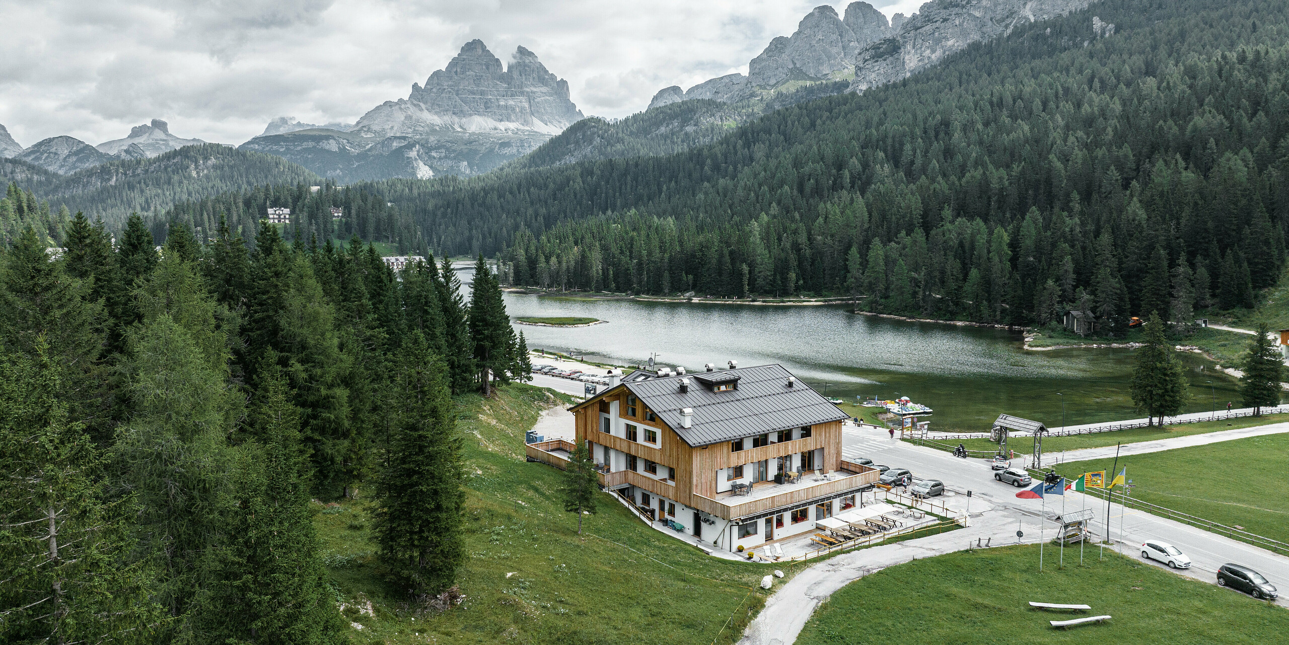 Das malerische Chalet 'Alpenrose' in idyllischer Bergkulisse, ausgestattet mit einem langlebigen PREFALZ Dach in der eleganten Farbe P.10 Nussbraun. Das robuste, matt erscheinende PREFA Dach harmoniert perfekt mit der natürlichen Holzfassade des Chalets, bietet optimalen Schutz gegen Witterungseinflüsse und fügt sich nahtlos in die alpine Umgebung ein.