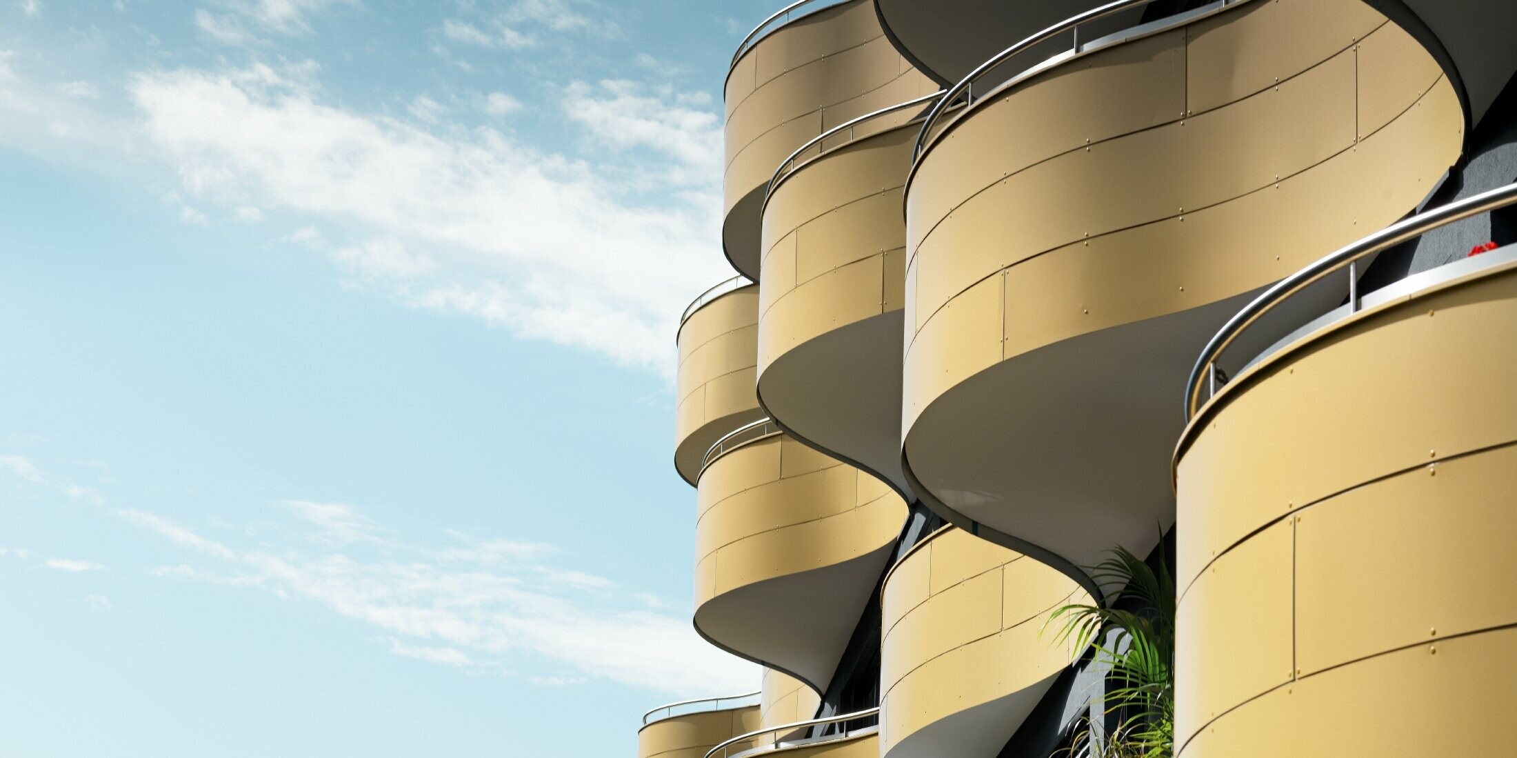 Wellenförmige Balkone eines Wohnhauses in Graz, verkleidet mit PREFA Aluminium Verbundplatten in Gold