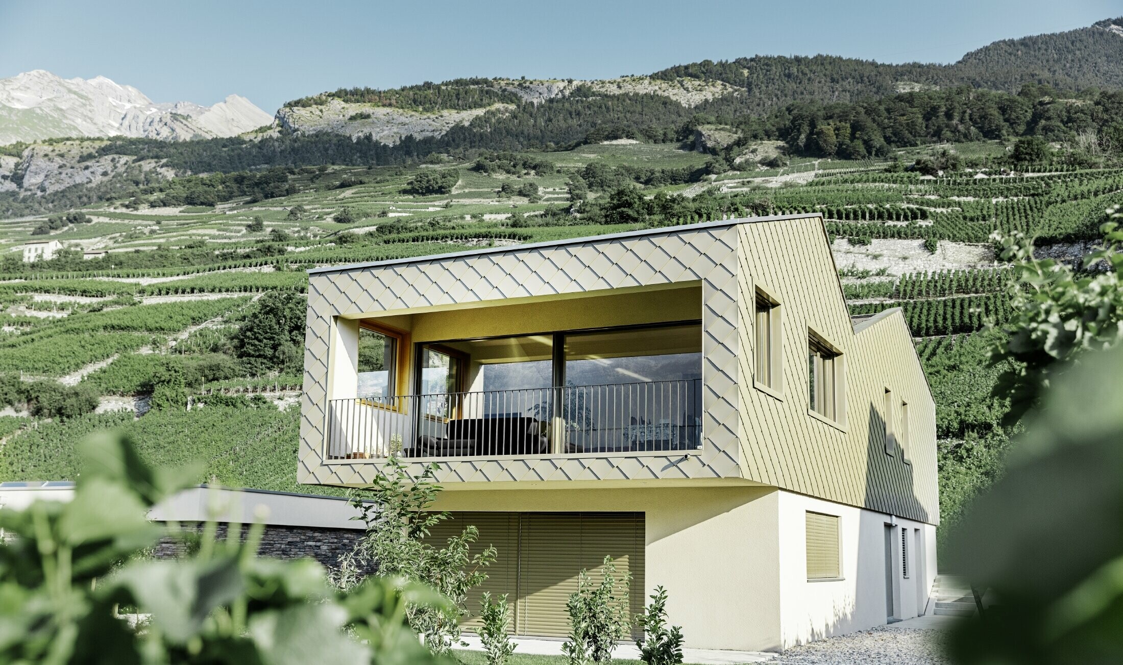 modernes Einfamilienhaus mitten in den Weinbergen des Rhônetals mit 4 unterschiedlichen Dachflächen und offener Galerie mit einer Rautenfassade in bronze
