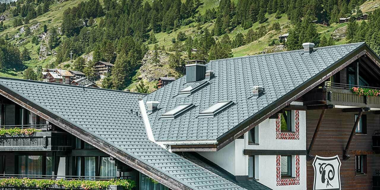 Hotelalpenhof in Zermatt mit dem Matterhorn im Hintergund, Balkonen, dunkler Holzfassade und einem PREFA Aluminiumdach in anthrazit