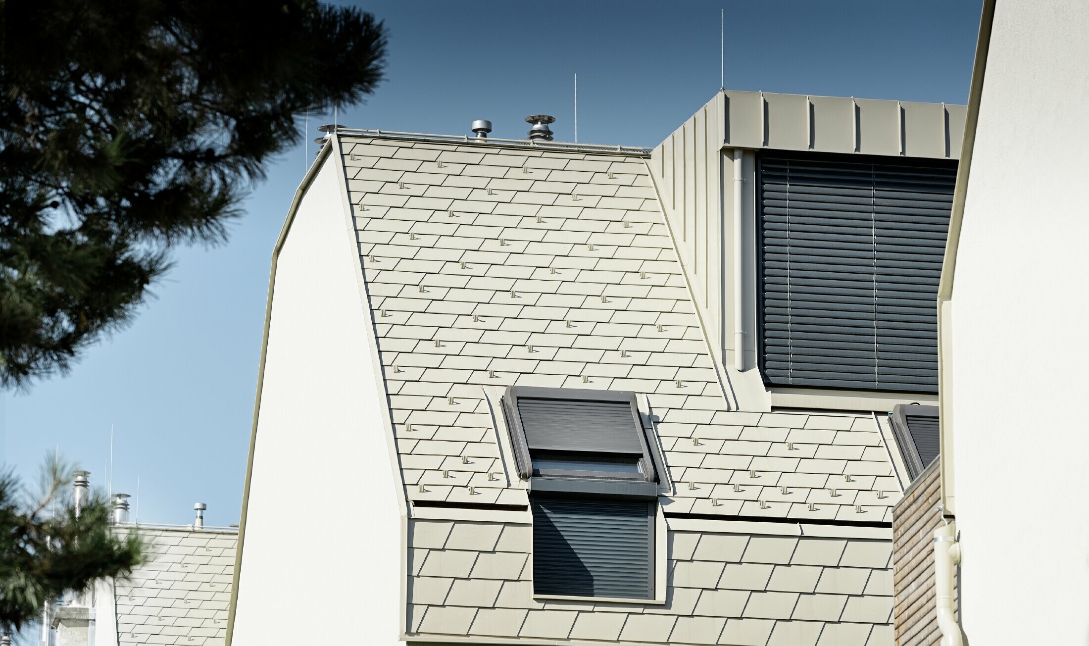 neue Wohnhausanlage mit großer Aluminium Dachfläche und vielen Dachflächenfenstern 