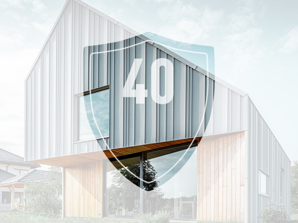 Bildet viser et skilt med tallet «40», som skal representere garantien på PREFAs aluminiumsprodukter, foran en moderne enebolig.