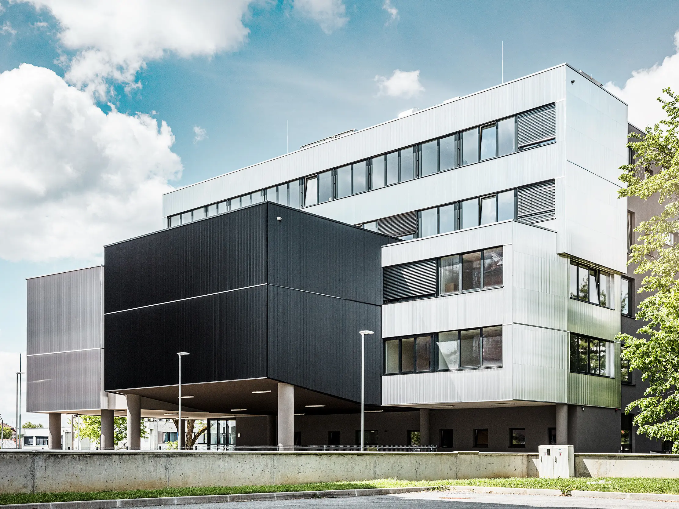 Sidevisning av musikkskolen i Bjevolar med en moderne PREFA-fasade i sikksakkprofil. Fasaden er holdt i svart og aluminiumblank, og de geometriske formene gir et markant, minimalistisk design.