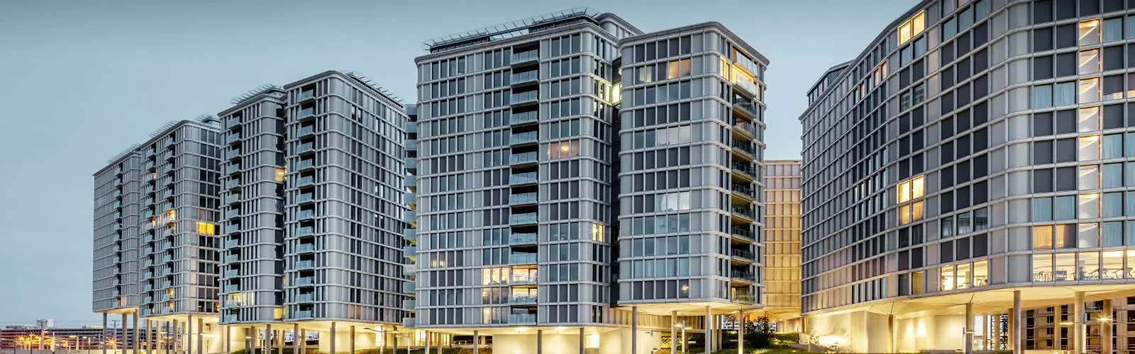 Vorderansicht der Belvedere Apartments am Abend. Die PREFA Profilwelle wurde mit Glas und Keramikelementen kombiniert