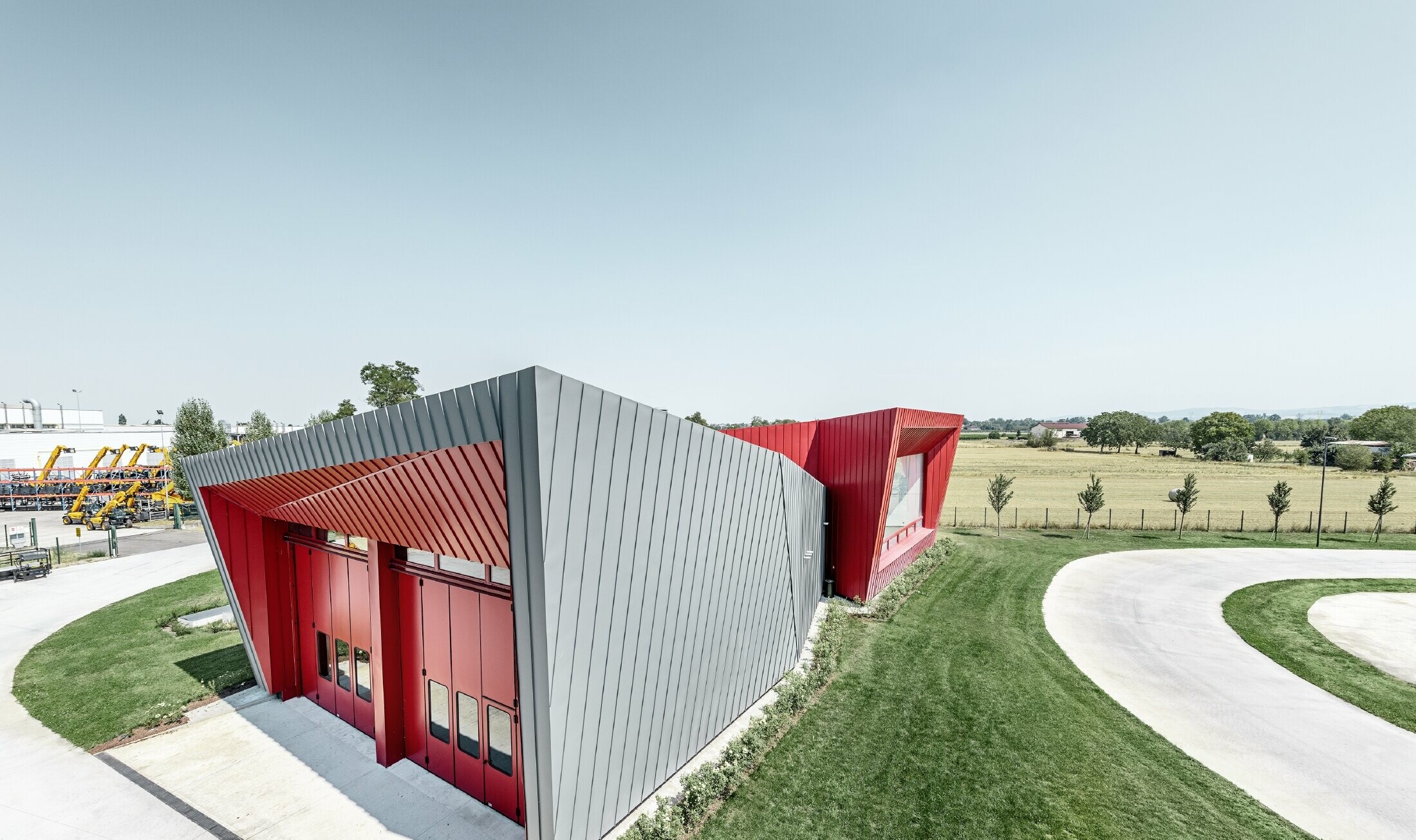 modernes Trainingscenter von Dieci in Montecchio Emilia ,Italien, mit Tribüne mit Aluminiumfassade mit Prefalz in hellgrau und Falzonal in karminrot 