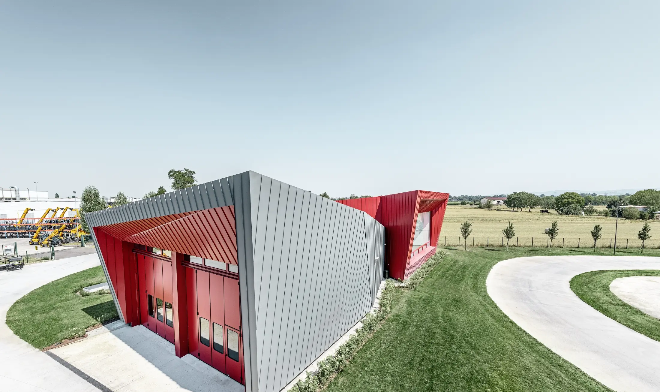 modernes Trainingscenter von Dieci in Montecchio Emilia ,Italien, mit Tribüne mit Aluminiumfassade mit Prefalz in hellgrau und Falzonal in karminrot 