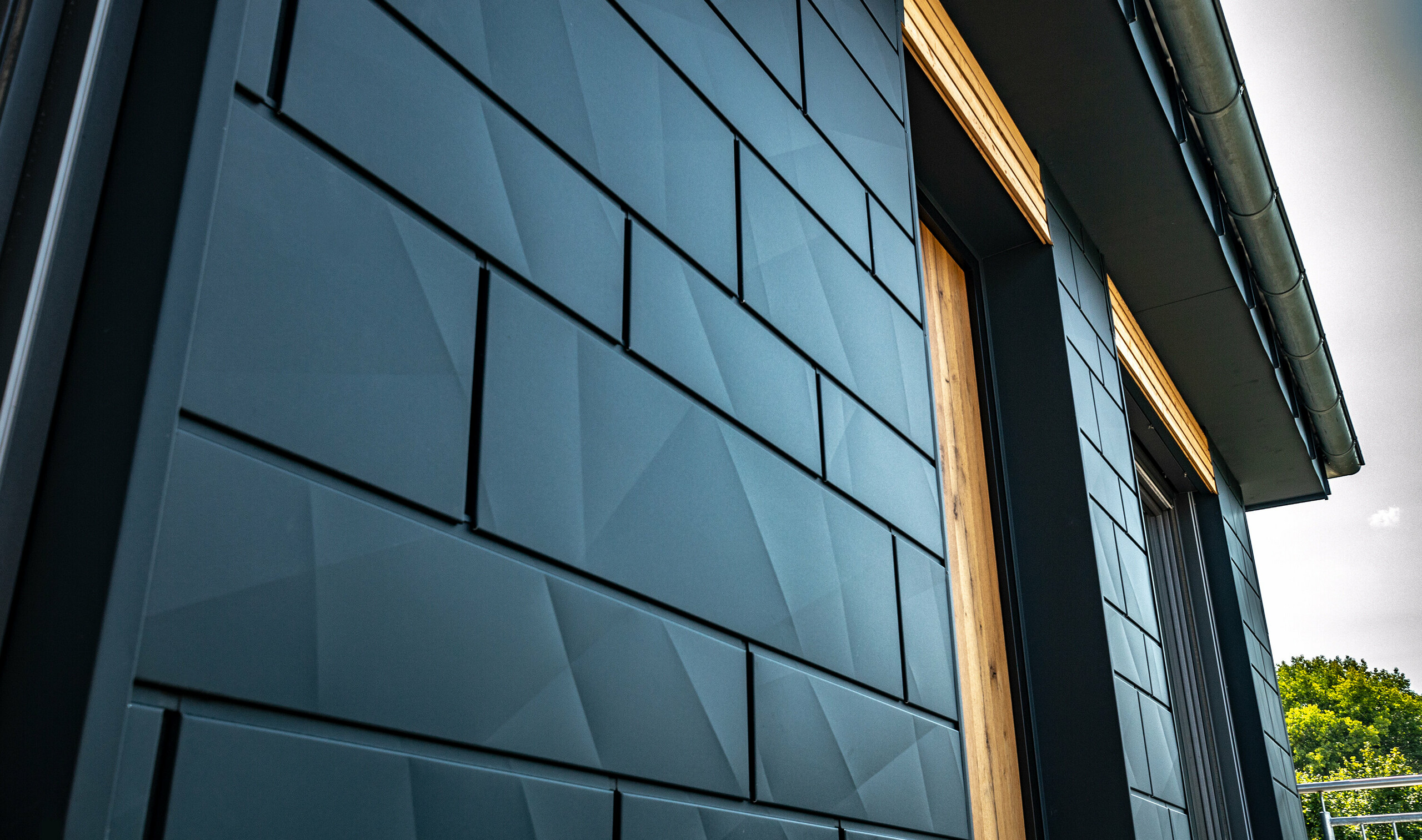 Fasade med PREFA Siding.X i antrasitt med balkongdører og store glassflater blandet med en trefasade.