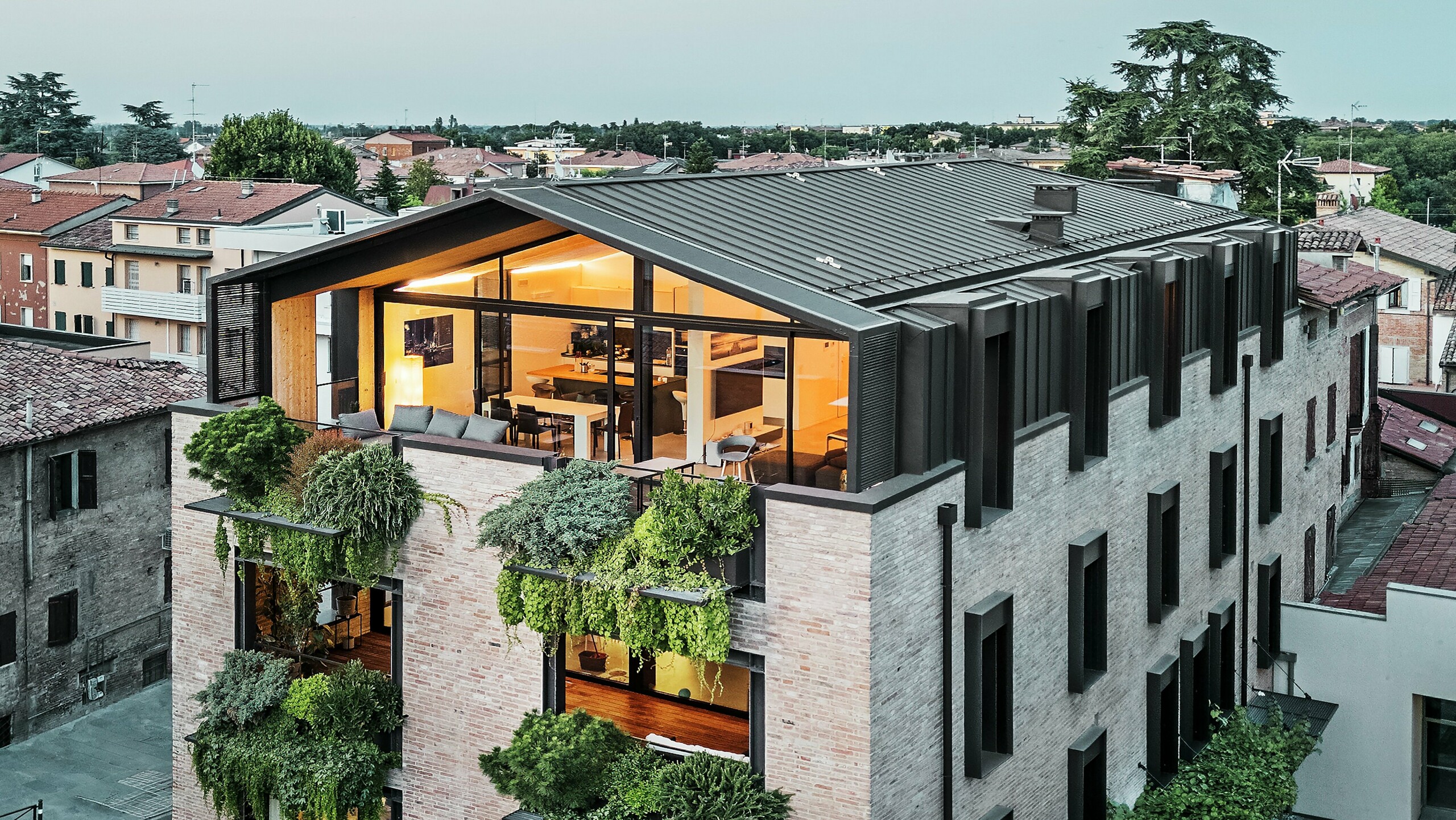 Održiva stambena kuća u Italiji s PREFALZ aluminijskim krovom i ozelenjenom fasadom od opeke.