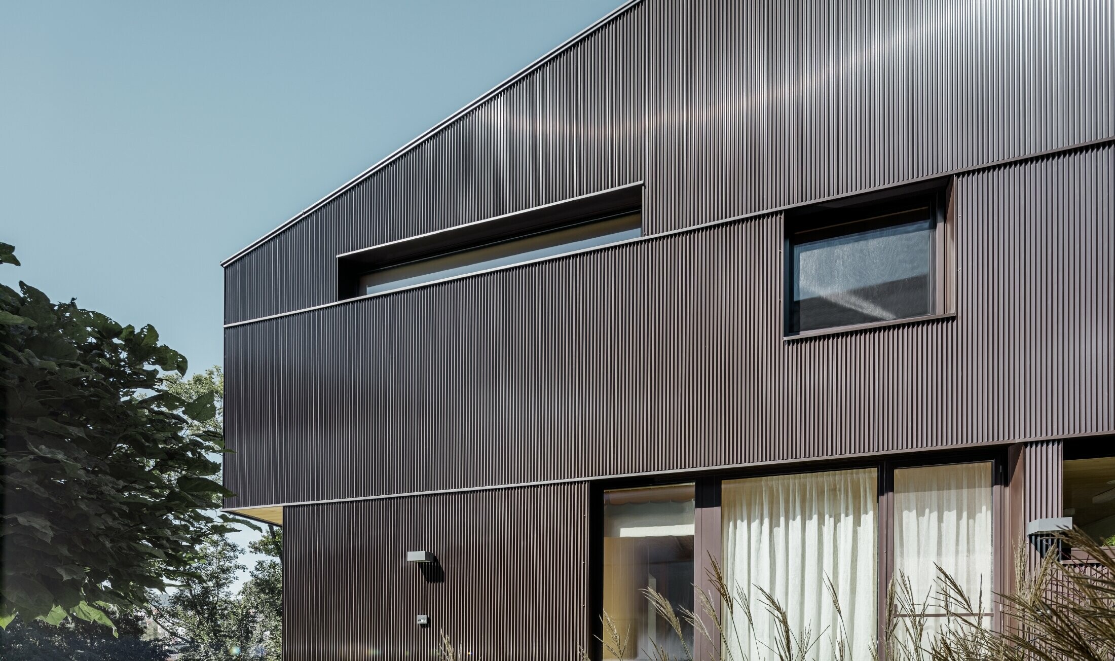 Moderne enebolig med fasadekledning fra PREFA – sikksakkprofil i brunt.