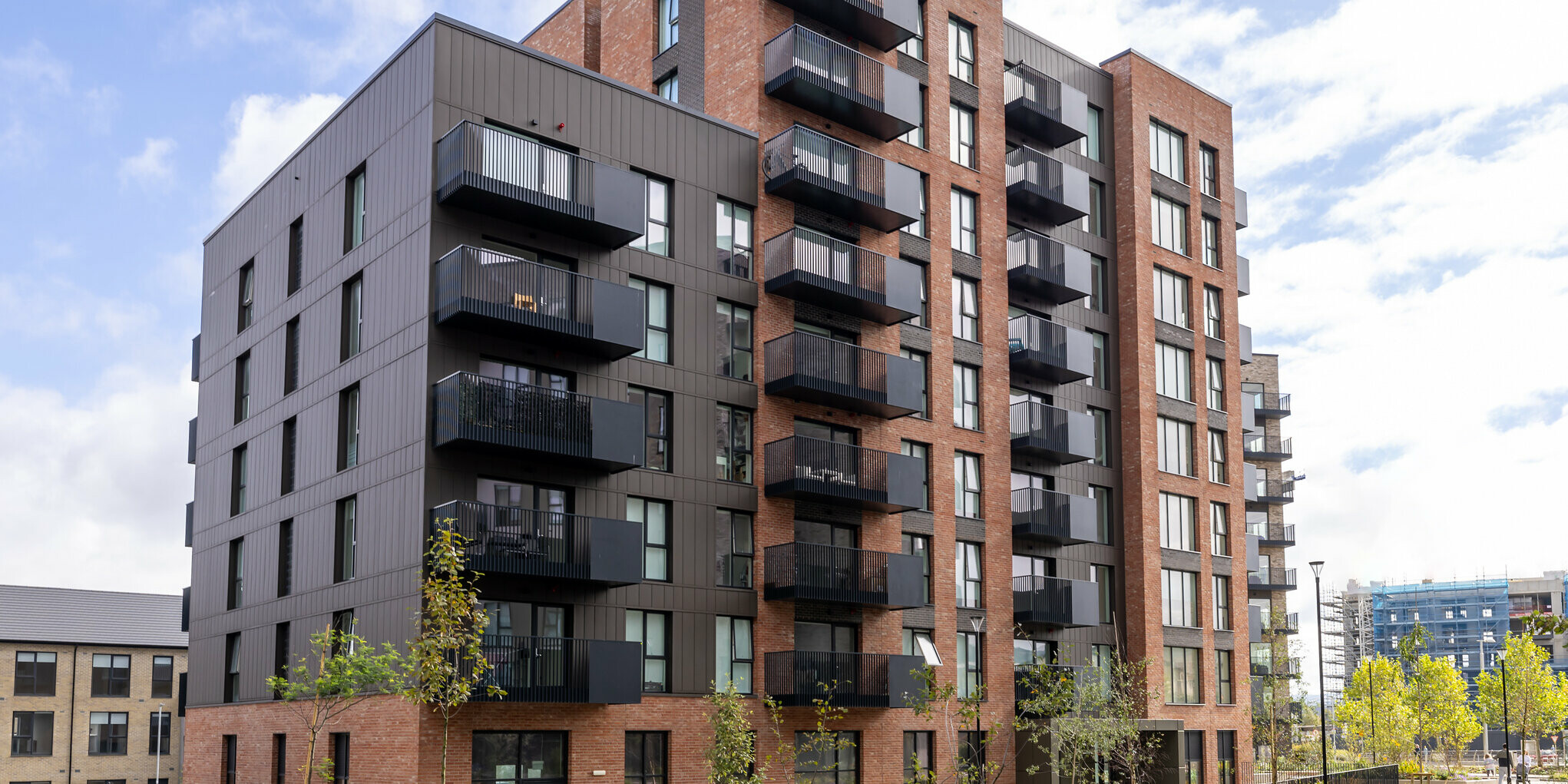 Frontansicht der Citywest Apartments in Dublin. Kombination aus traditioneller Ziegelfassade und 700 m² PREFA Sidings aus hochwertigem Blech in der Farbe P.10 Braun. Die Aluminiumpaneele verleihen dem Wohngebäude ein modernes, urbanes Erscheinungsbild mit hoher Witterungsbeständigkeit.