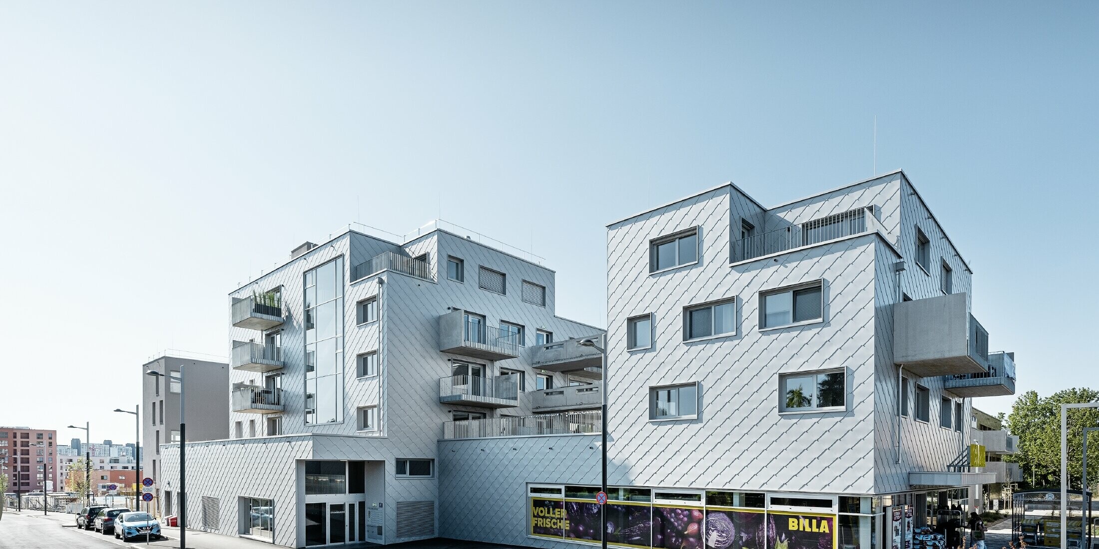 Boliganlegg med flatt tak og rombekledning på fasaden med PREFA veggrombe 44 × 44 i sølvmetallic