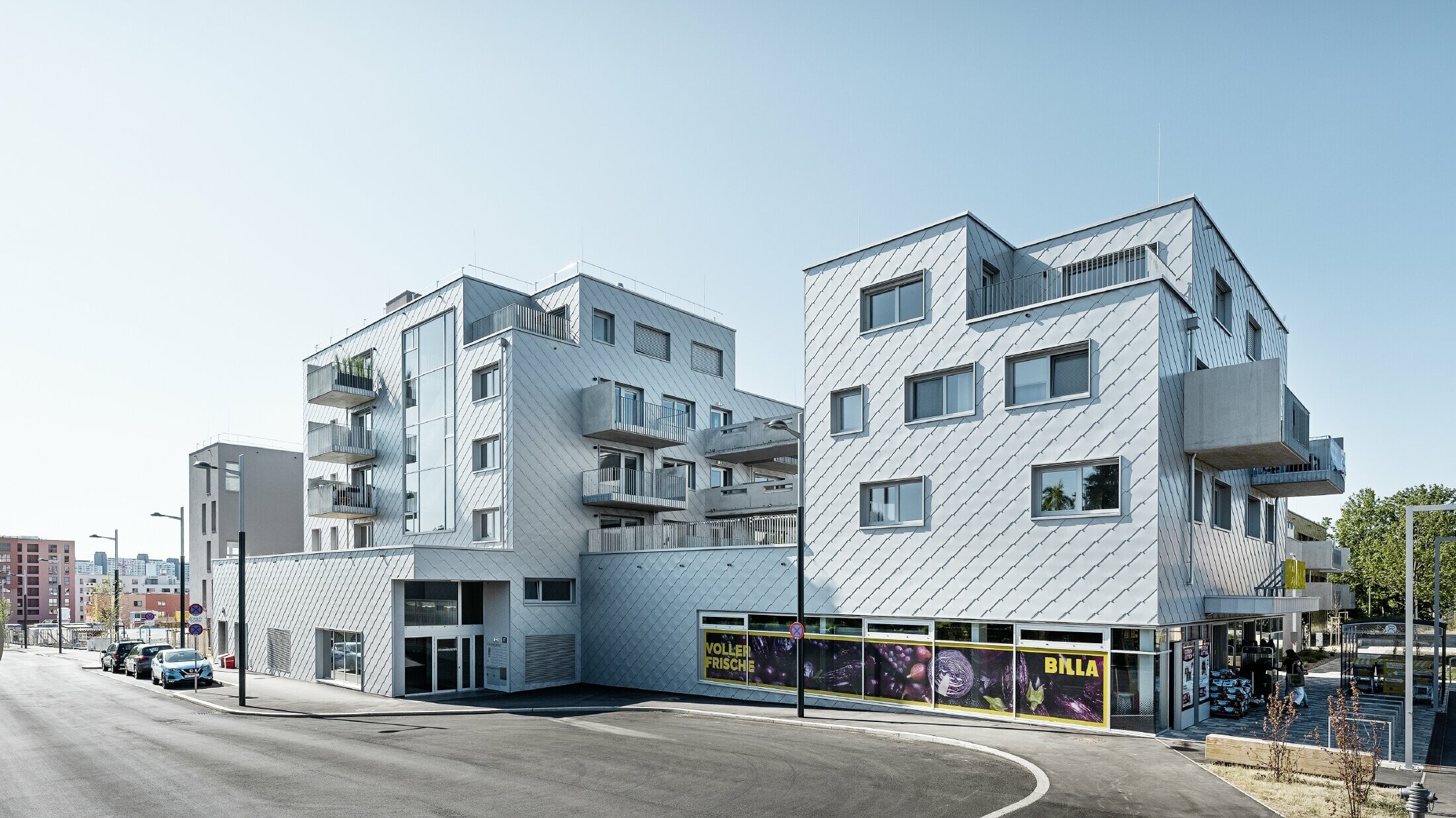 Boliganlegg med flatt tak og rombekledning på fasaden med PREFA veggrombe 44 × 44 i sølvmetallic