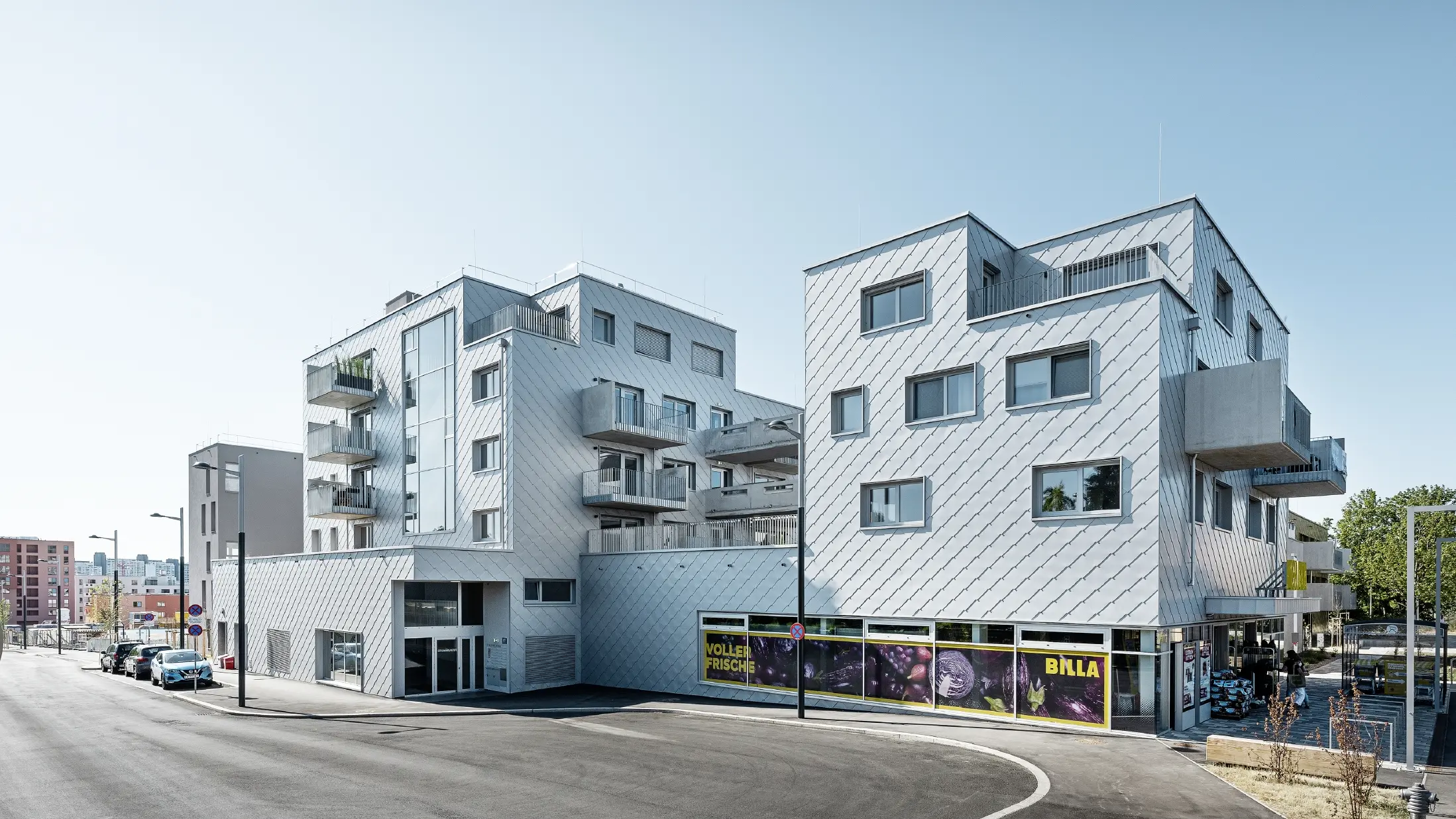 Boliganlegg med flatt tak og rombekledning på fasaden med PREFA veggrombe 44 × 44 i sølvmetallic