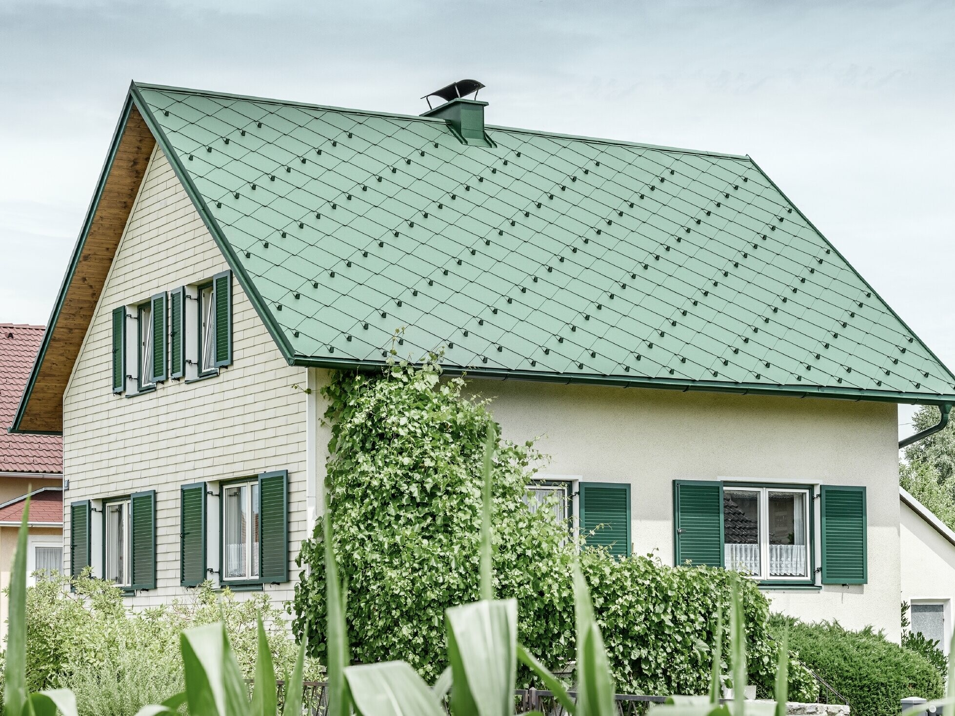 Klassisk enebolig med saltak og takkledning i mosegrønn aluminium med grønne vinduskodder