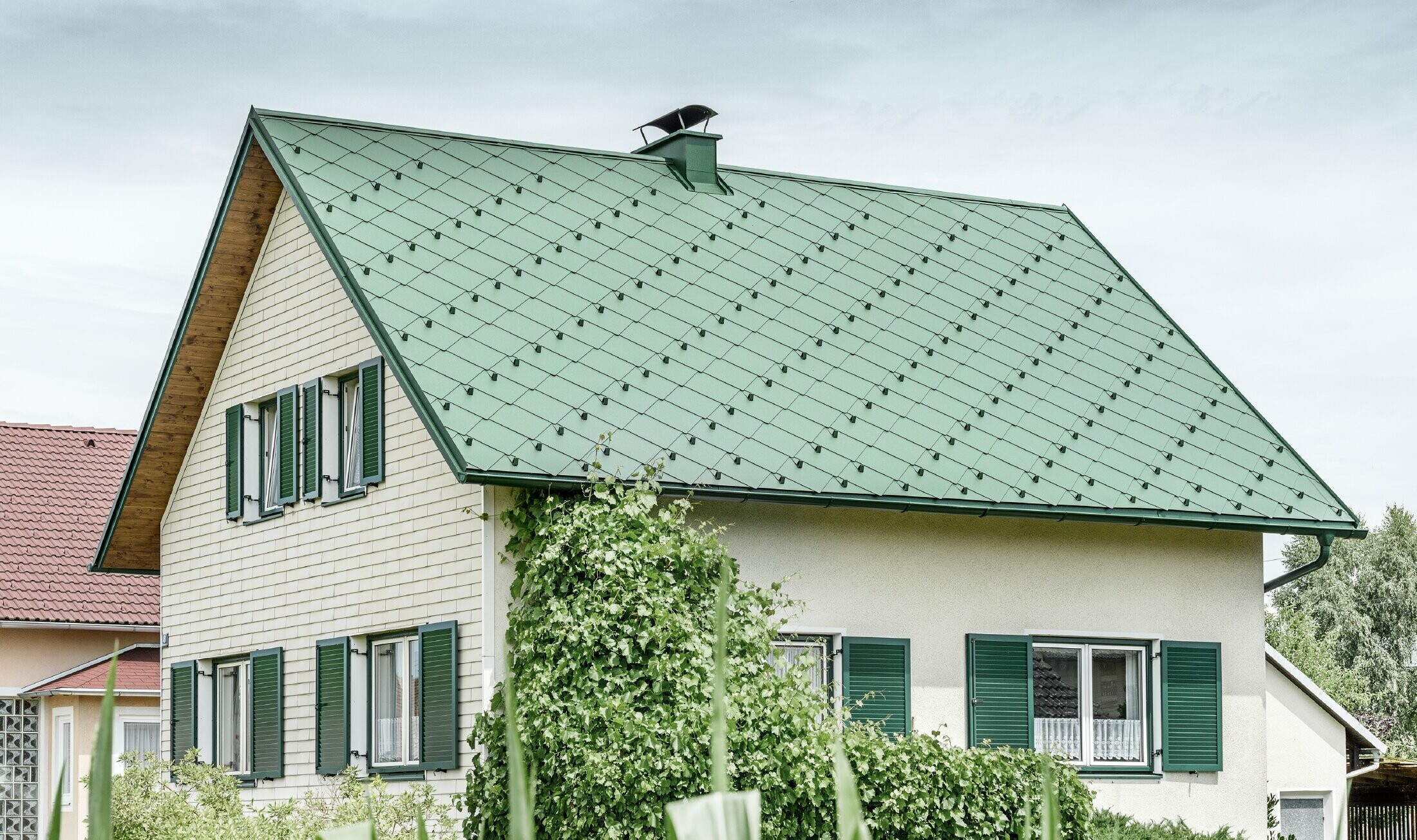 Klassisk enebolig med saltak og takkledning i mosegrønn aluminium med grønne vinduskodder