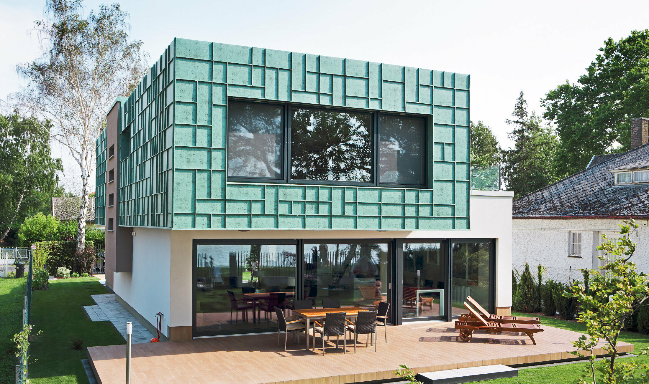Modernes Einfamilienhaus mit sturmsicherer Fassade, die mit PREFALZ in P.10 Patina Grün verkleidet wurde.