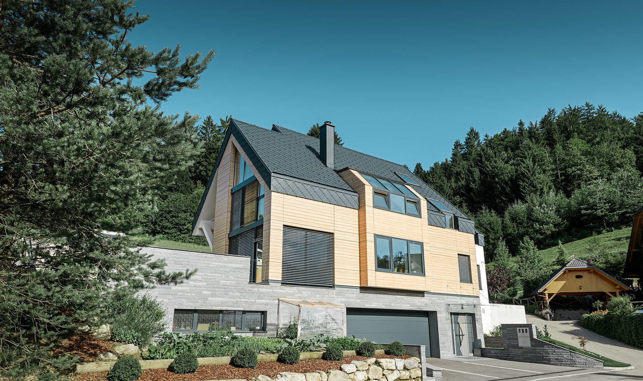 Einfamilienhaus mit Satteldach ohne Dachvorsprung mit einer Fassade in Holzoptik und einem Aluminiumdach in anthrazit