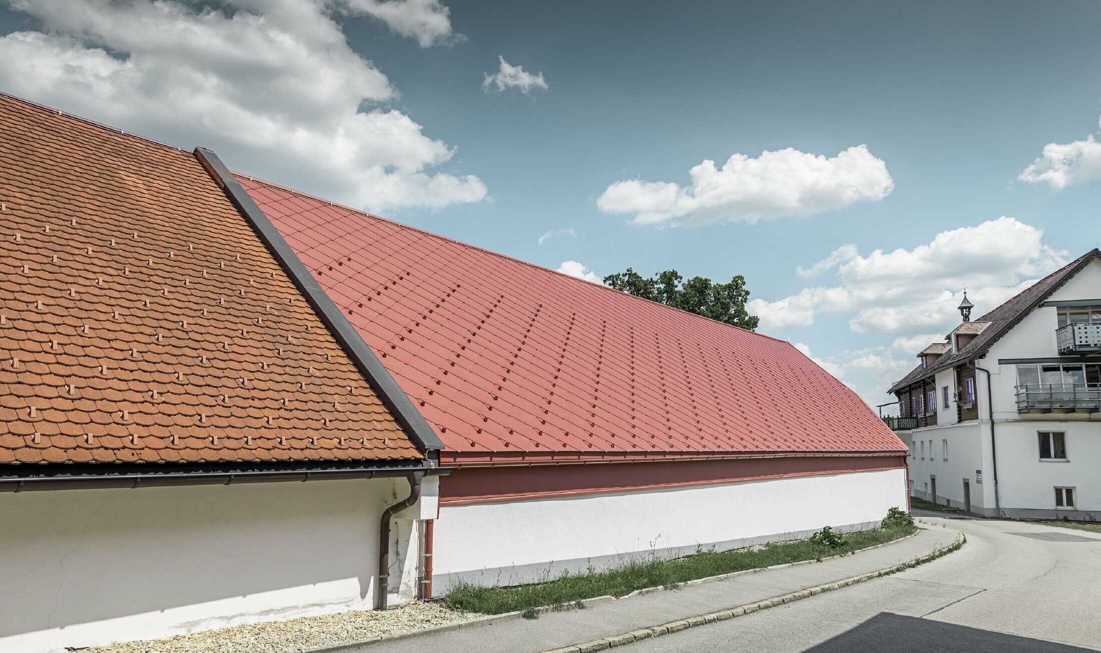 Foto fra utsiden av Kerzenwelt i Schlägl. Taket er kledd med PREFA aluminiumsrombe i stort format på 44x44 i oksydrød.