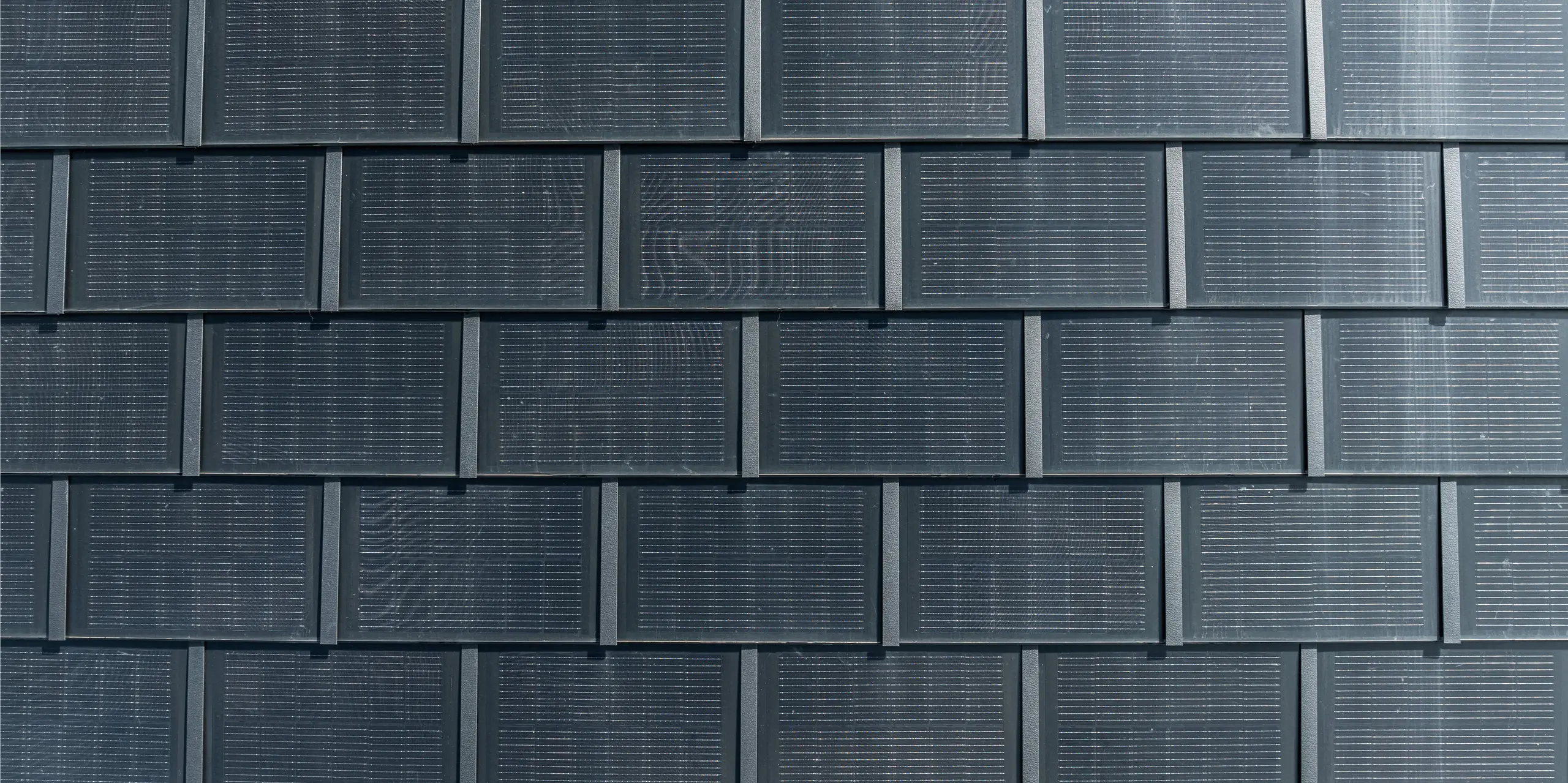 PREFA soltakpaneler med integrerte solcellemoduler i detalj. Denne innovative løsningen kombinerer estetisk takdesign med bærekraftig energiproduksjon. De slitesterke, lette og værbestandige takpanelene i aluminium gir maksimal effektivitet med minimal innvirkning på arkitekturen. Perfekt for moderne og verneverdige bygninger som verdsetter miljøvennlig teknologi.